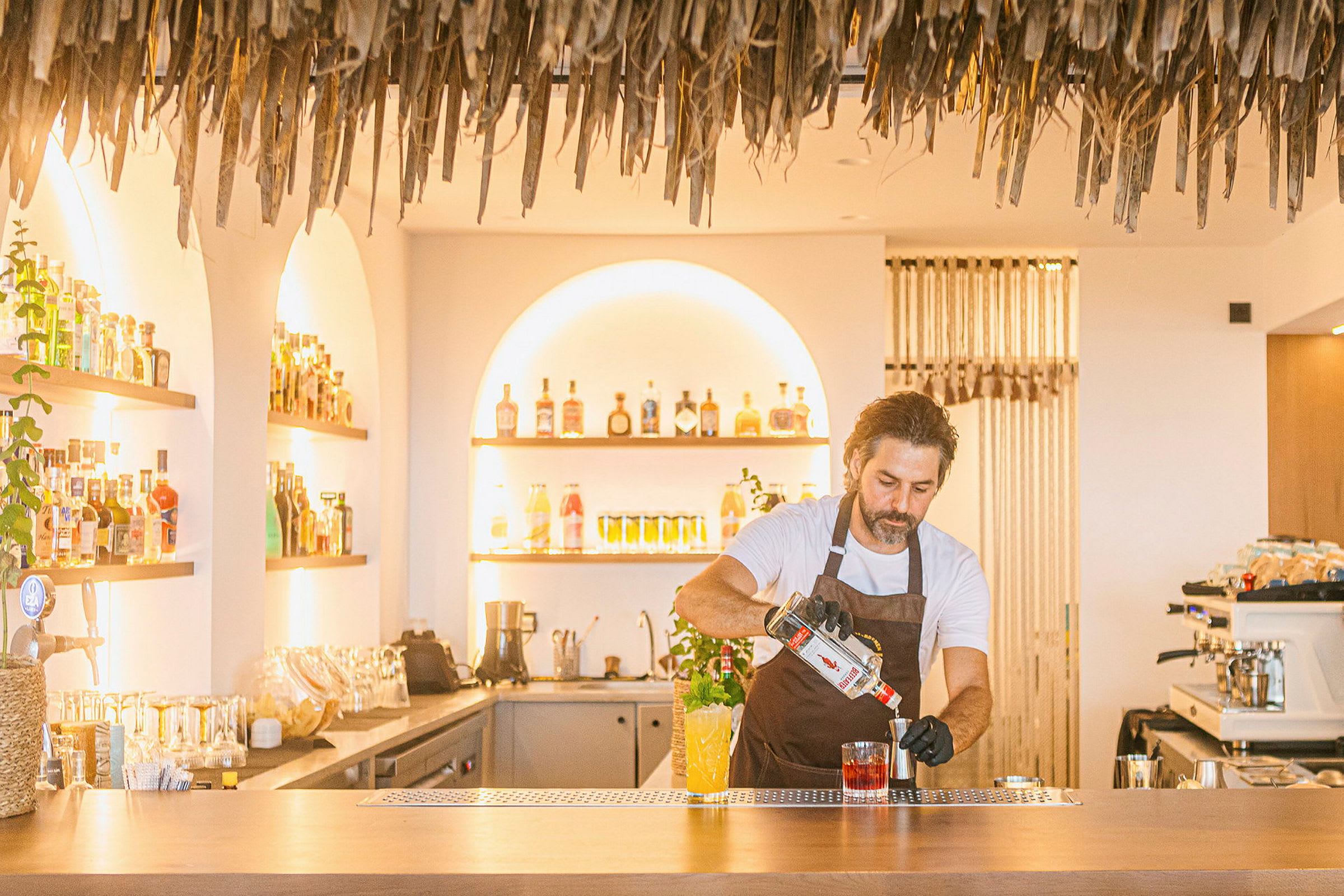 En bartender som blandar en drink vid en cocktailbar. (AI-genererad text)