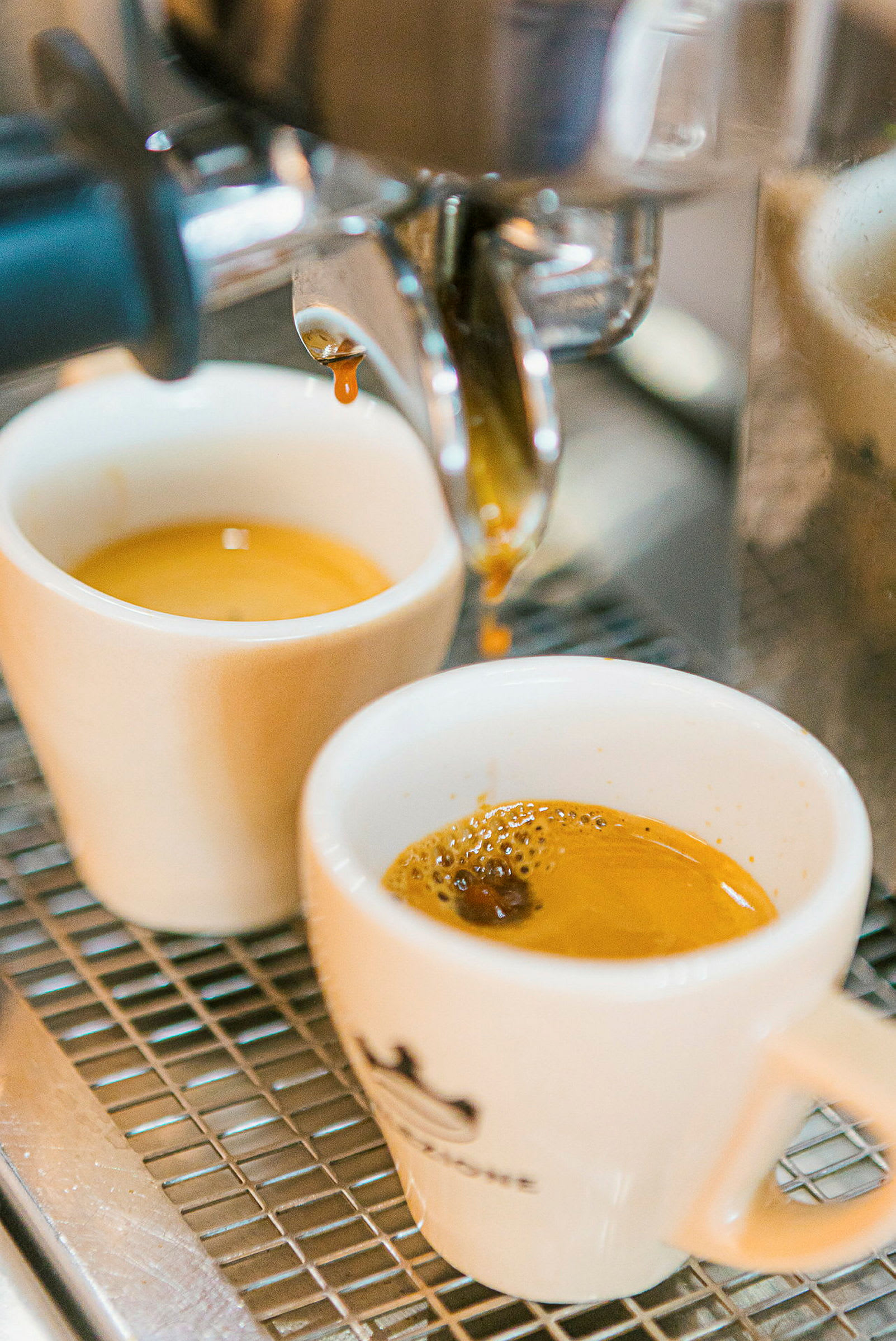 Espressobryggning med två vita koppar under maskinen. (AI-genererad text)
