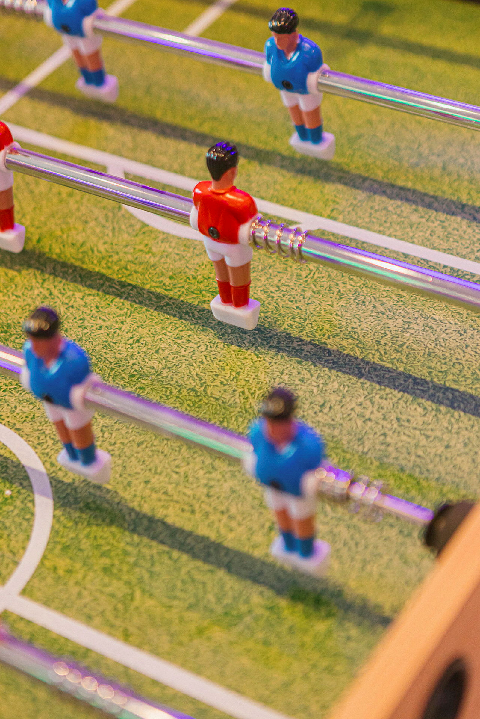 Bordfotbollsspel med figurer i röda och blå uniformer. (AI-genererad text)