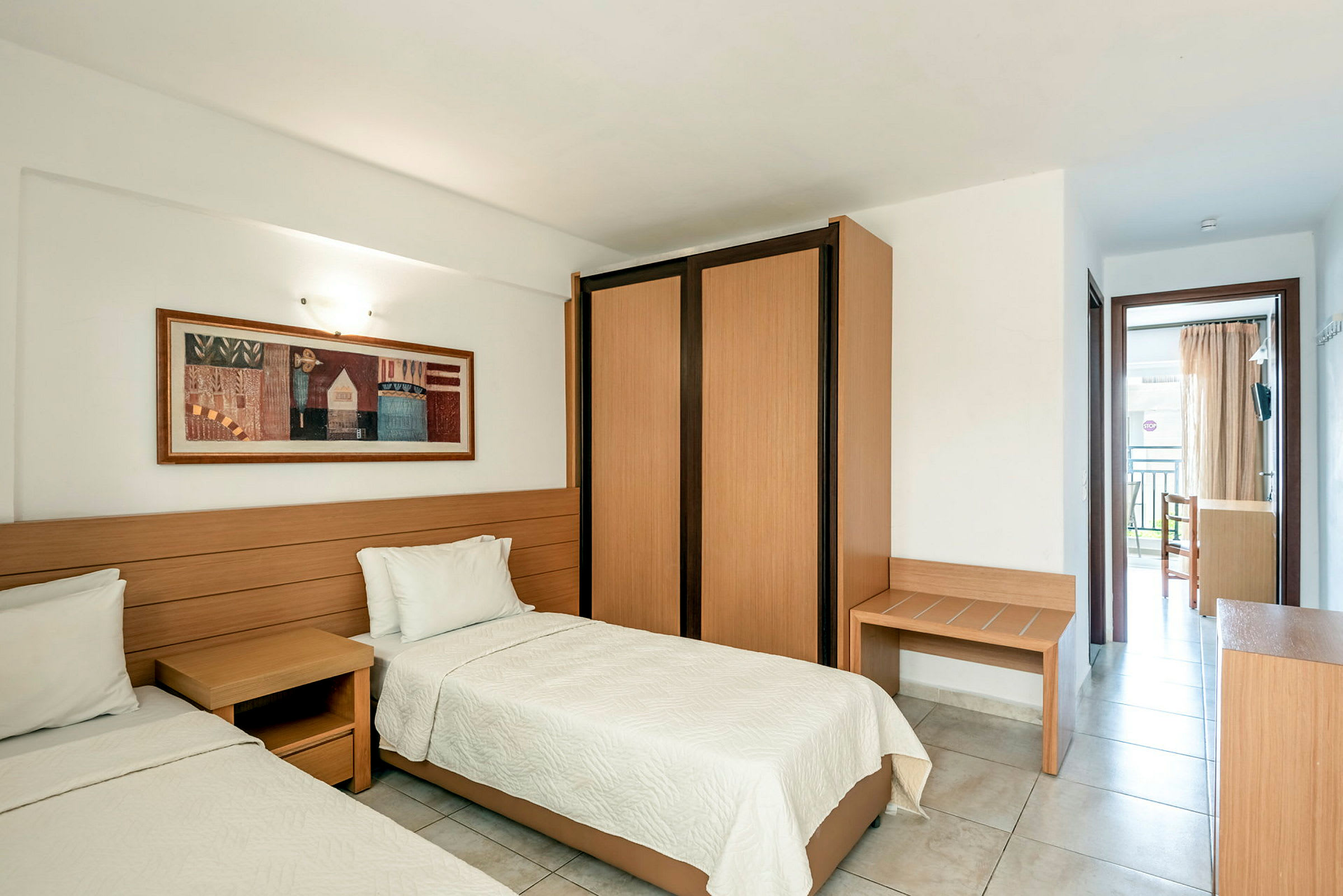 En hotellrum med två enkelsängar, en träväggpanel och en garderob. (AI-genererad text)
