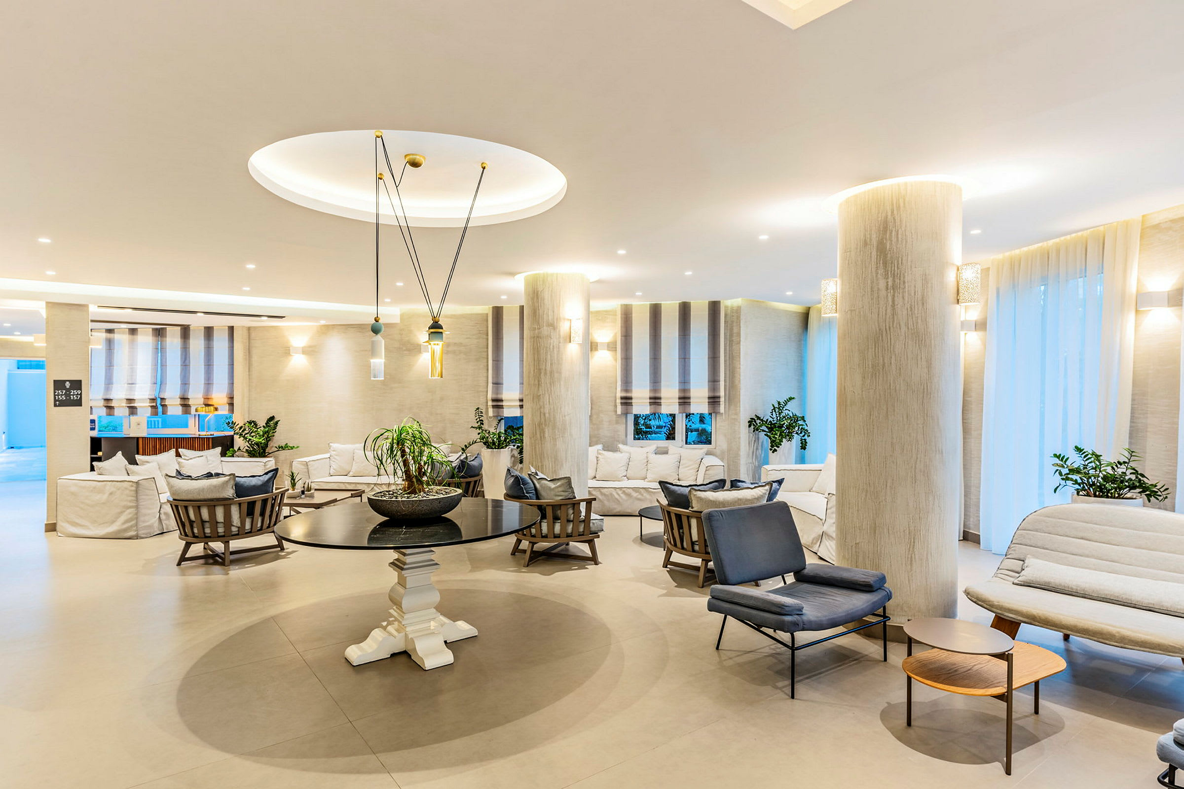Ljust och stilfullt inrett hotellobbymiljö med sittgrupper och dekorativa element. (AI-genererad text)