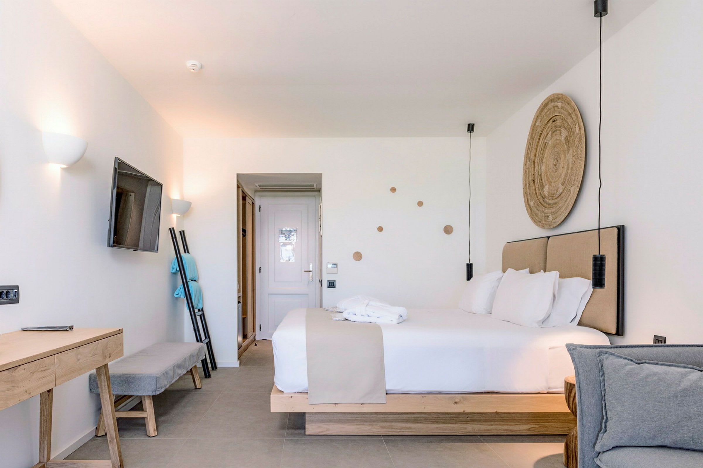 Modernt hotellrum med dubbelsäng, TV på väggen och skrivbord. (AI-genererad text)