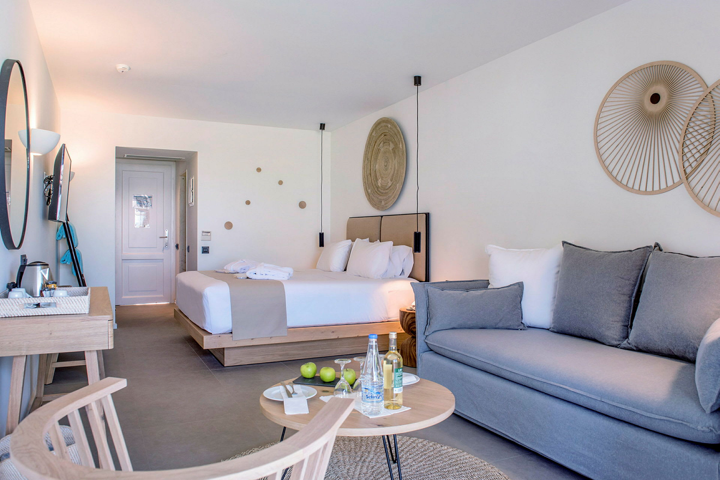 Hotellrum med en säng, soffa, och bord. (AI-genererad text)