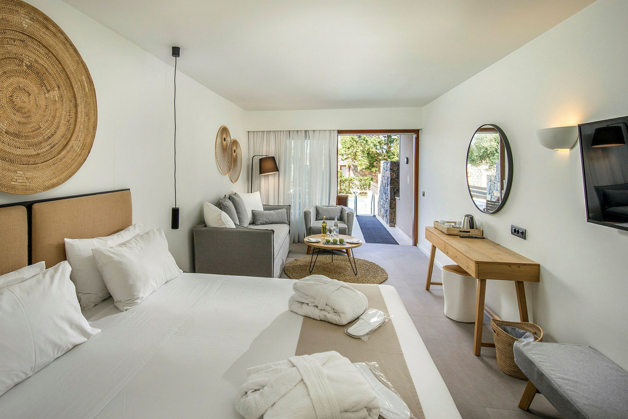 Modernt inrett hotellrum med säng, sittgrupp och möbler. (AI-genererad text)