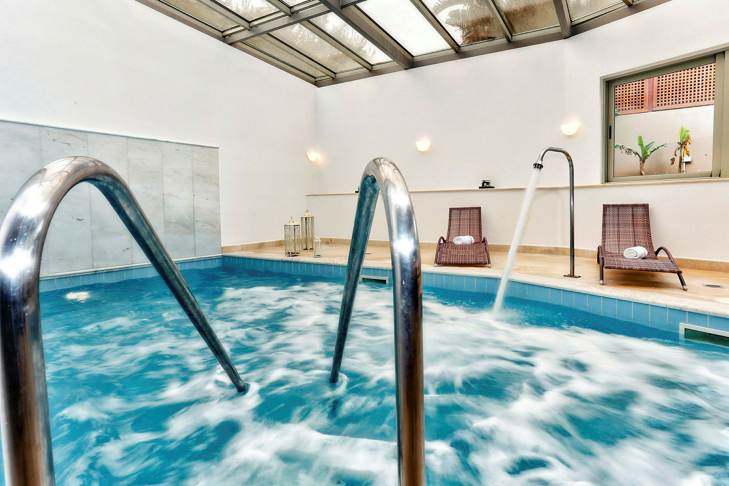 Inomhuspool med stolar och vattenstrålar. (AI-genererad text)