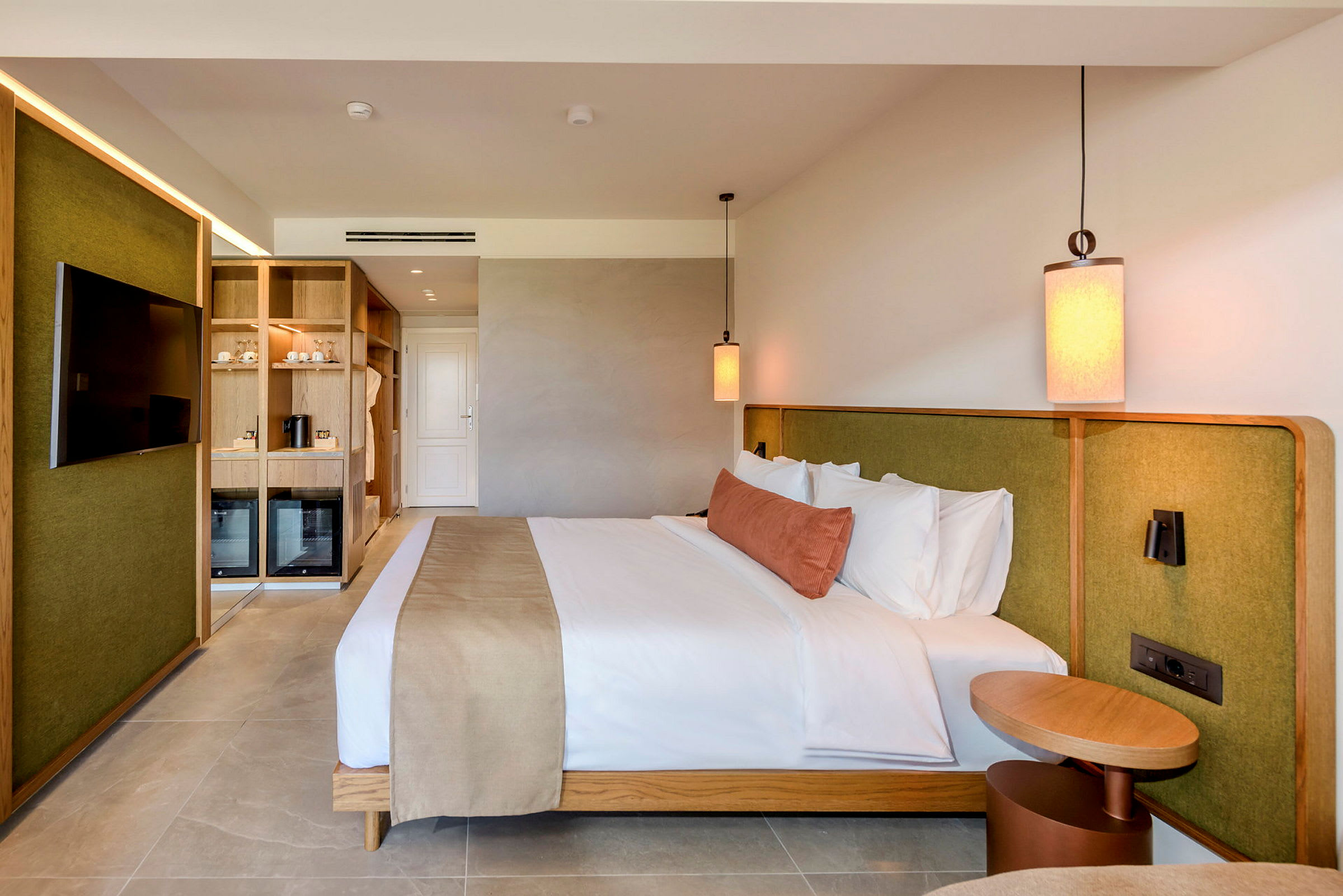 Bild av ett modernt hotellrum med en dubbelsäng, inredning i trä och gröna detaljer. (AI-genererad text)