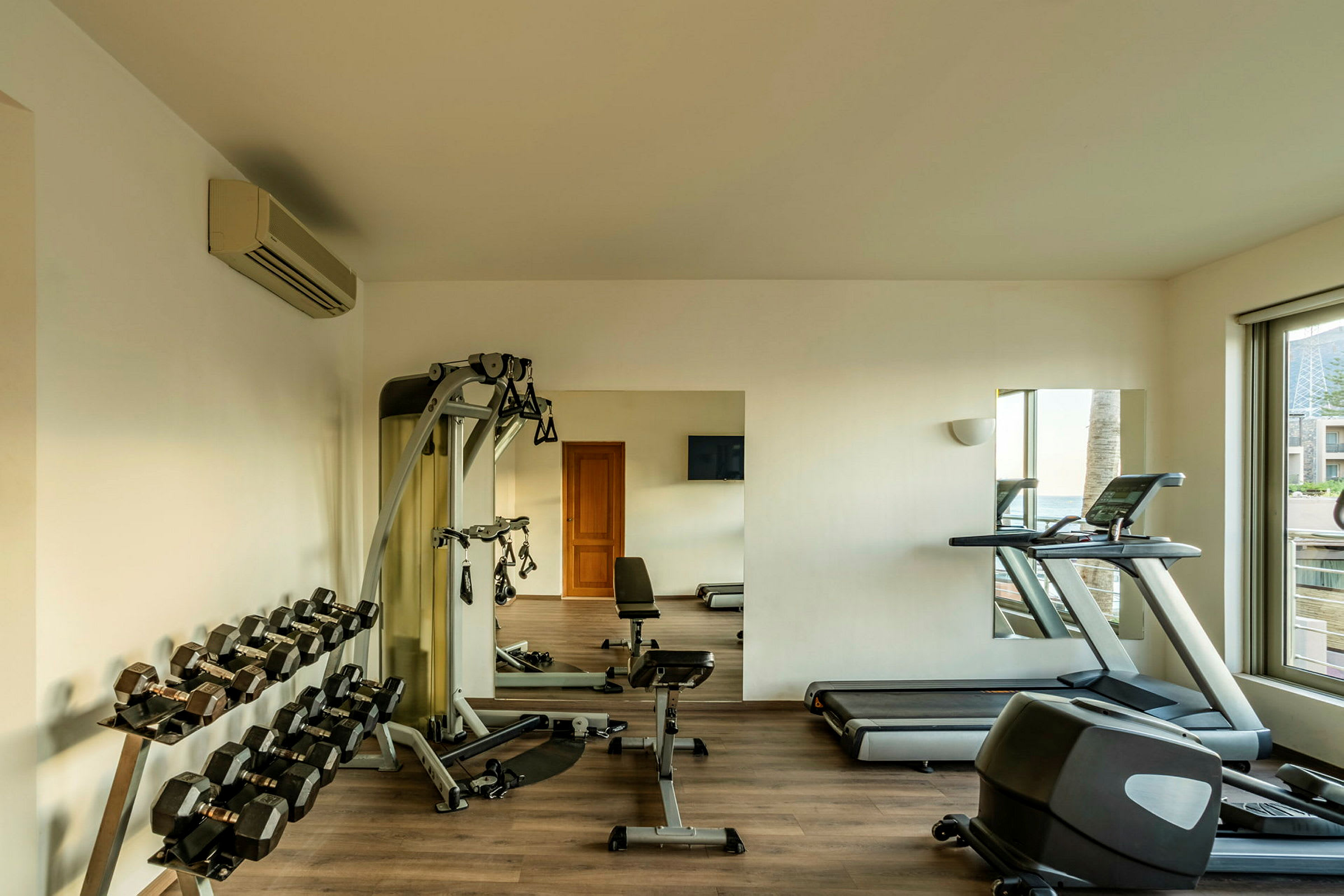 Ett gym med träningsutrustning som hantlar, träningsmaskiner och ett löpband. (AI-genererad text)