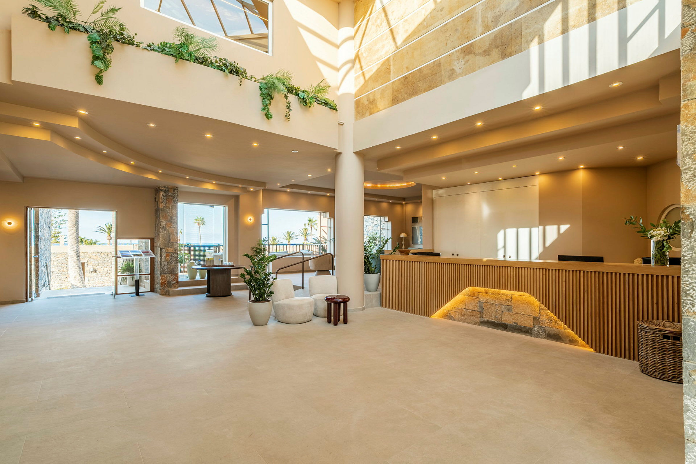 En modern hotellobby med en receptionsdisk och stora fönster som släpper in dagsljus. (AI-genererad text)