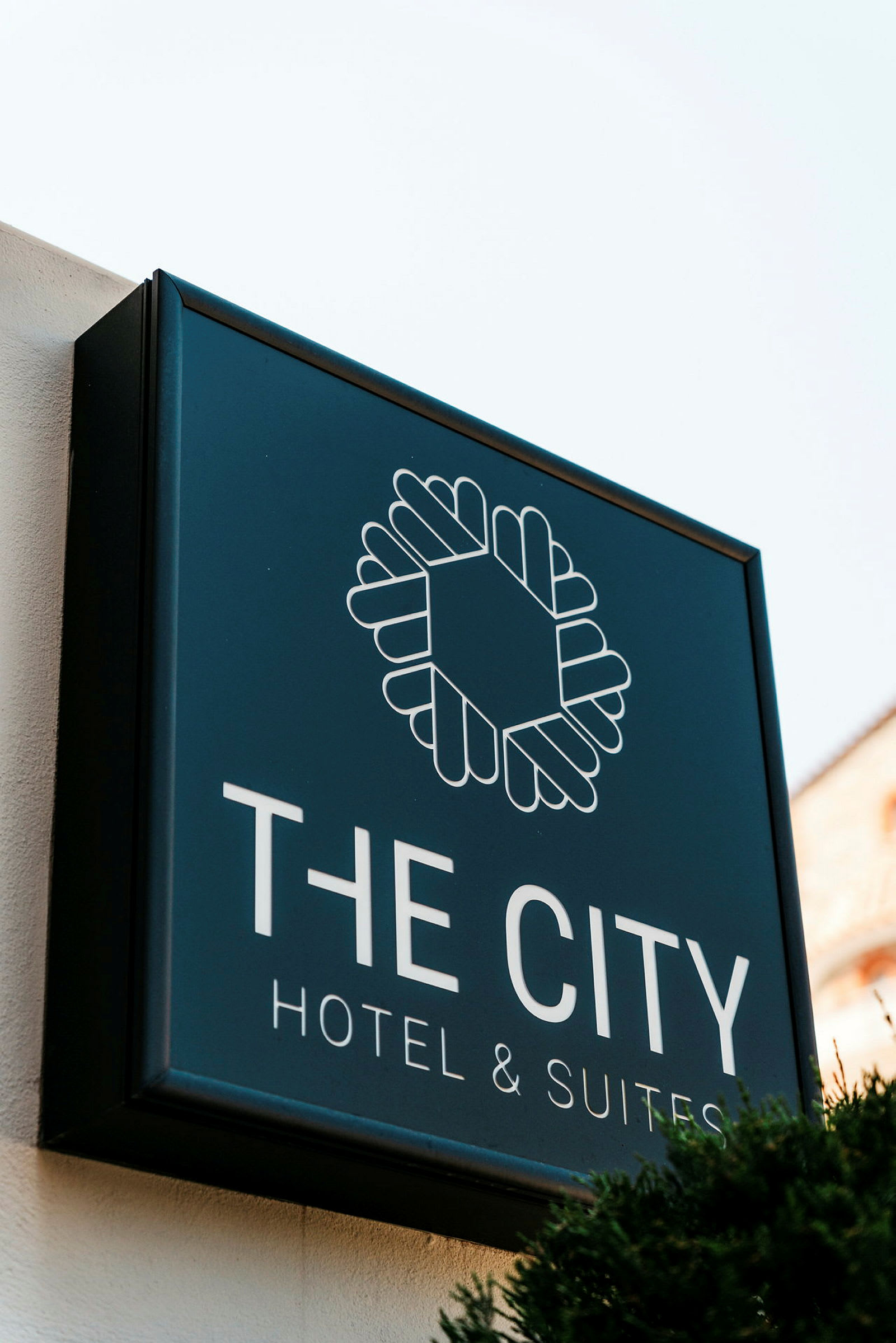 Skylt för "The City Hotel & Suites" mot ljus bakgrund. (AI-genererad text)
