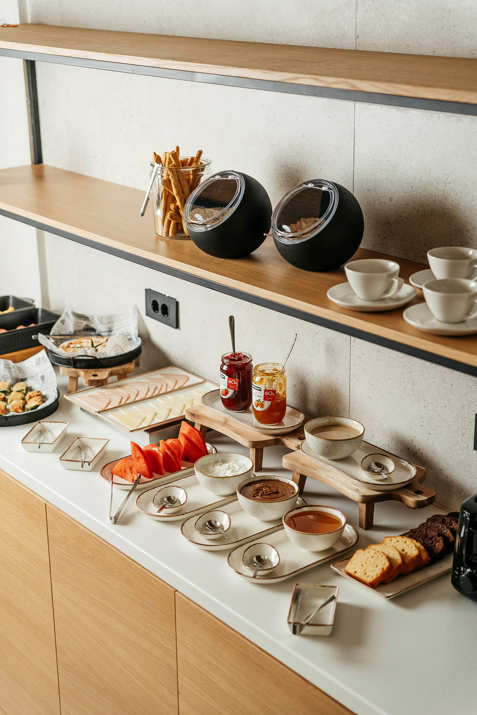 Frukostbuffé med bröd, marmelad, och frukt. (AI-genererad text)