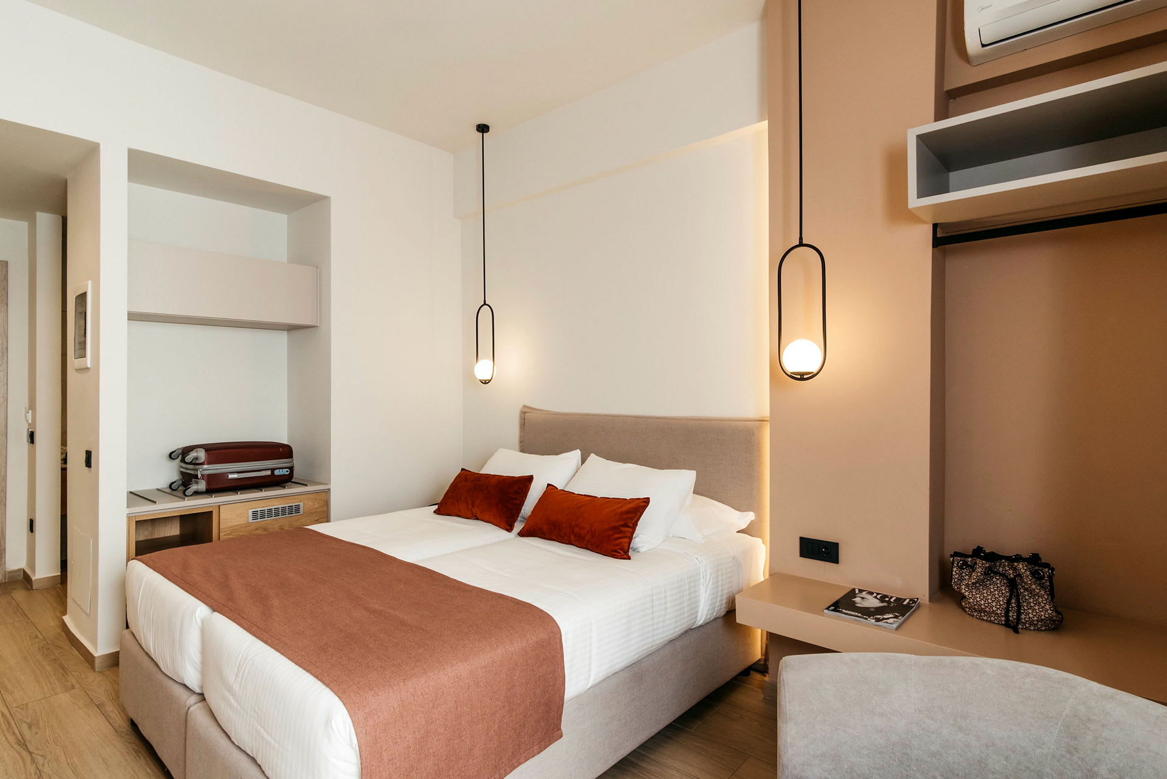 Ett modernt hotellrum med en dubbelsäng och eleganta hängande lampor. (AI-genererad text)