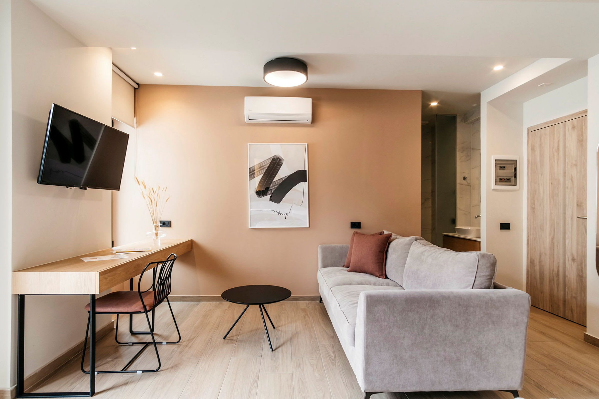 Ett modernt inrett vardagsrum med soffa, arbetsbord och TV. (AI-genererad text)
