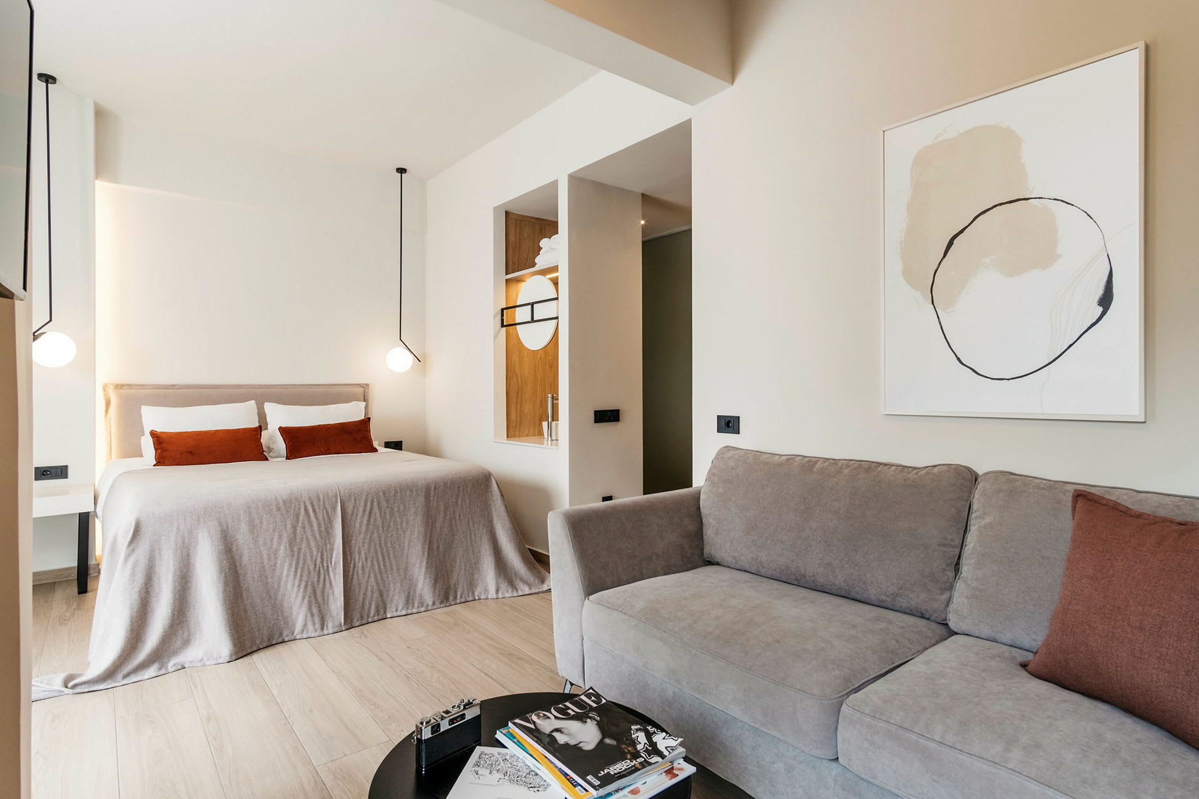 Ett modernt hotellrum med en stor säng, soffa och minimalistisk inredning. (AI-genererad text)