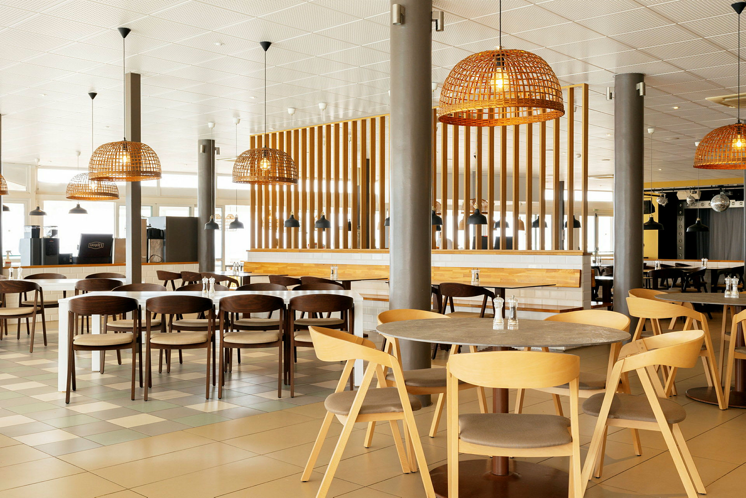 Bild av en modern restaurang med trämöbler och rottinglampor. (AI-genererad text)