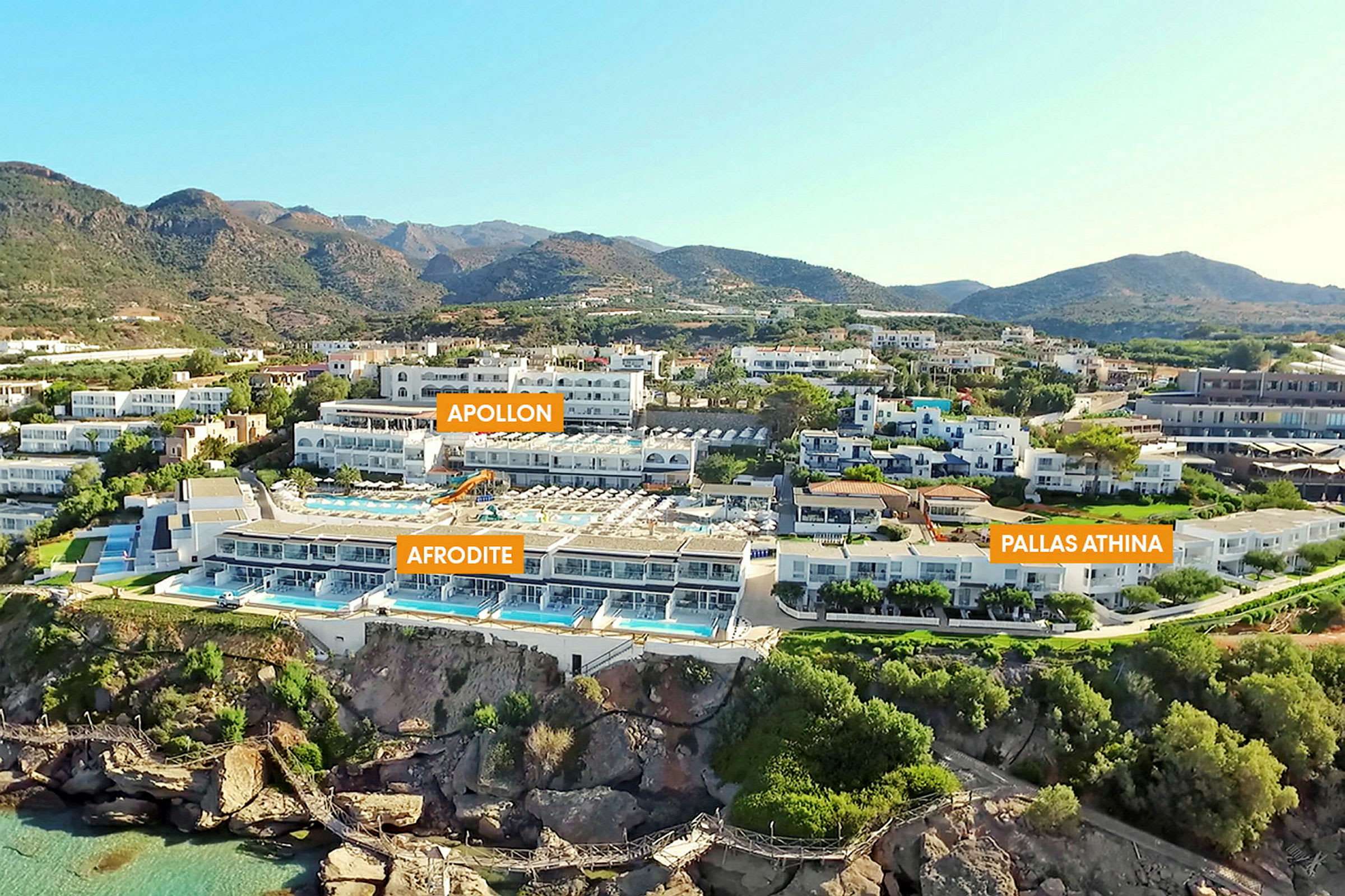 Flera hotellbyggnader med pooler, omgivna av grönska och berg. (AI-genererad text)