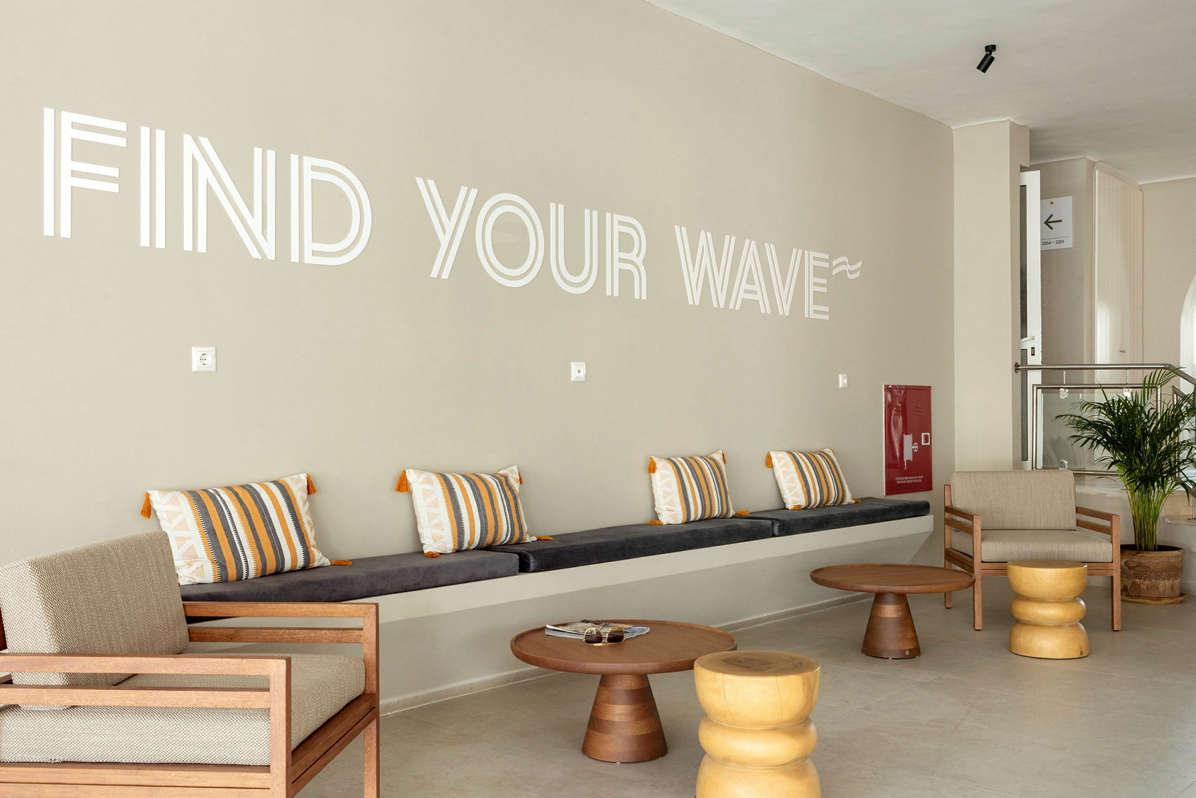 En lounge med sittplatser och texten 'Find Your Wave' på väggen. (AI-genererad text)