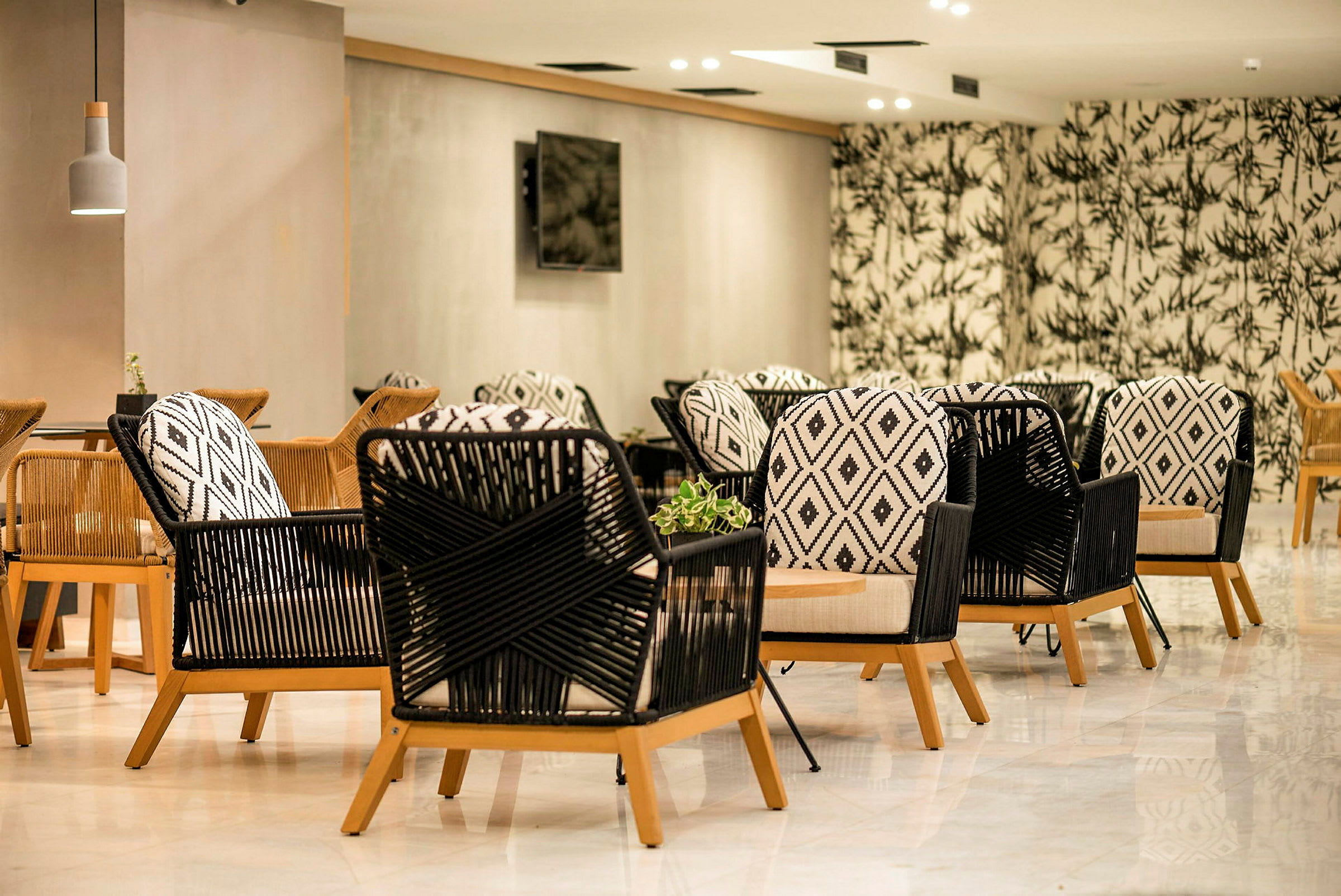 Bild av sittgrupp med moderna stolar med geometriska mönster och träben, placerade i ett rum med stilfull inredning och dekorativ tapet. (AI-genererad text)