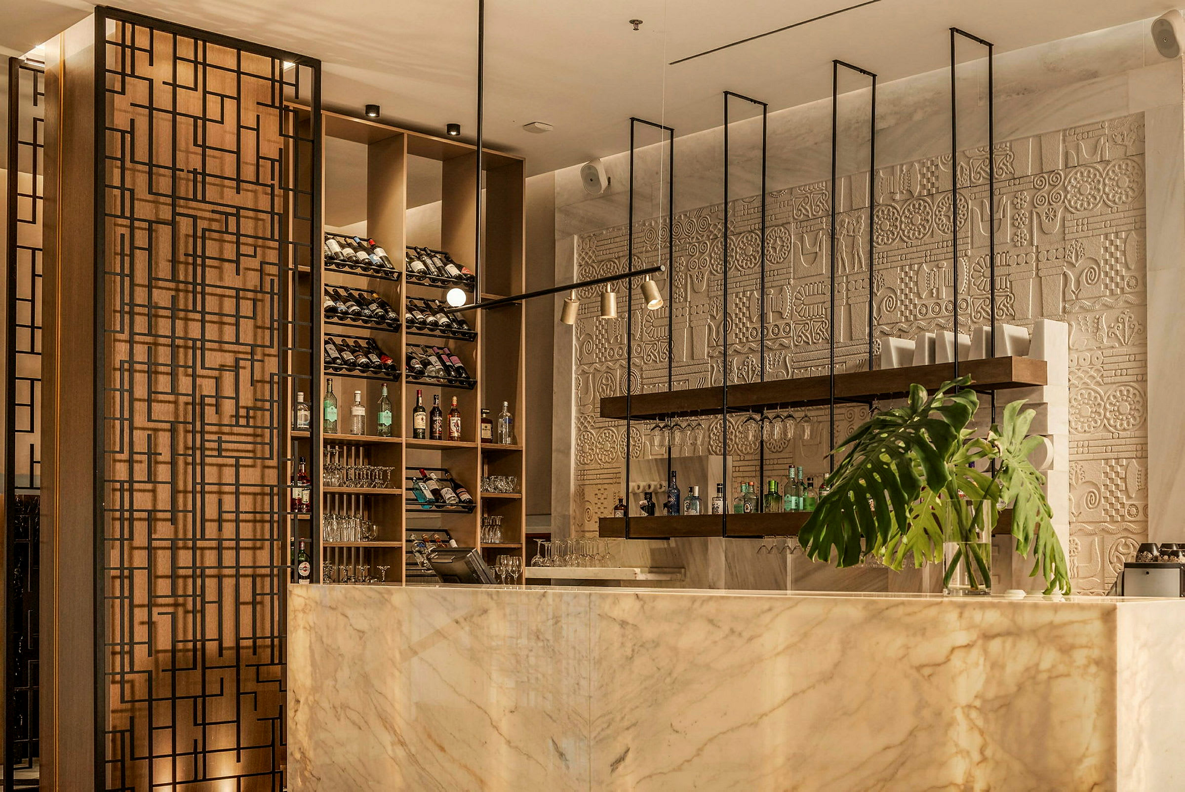 Elegant bar med marmordisk, vinställ, dekorativ vägg och växt. (AI-genererad text)