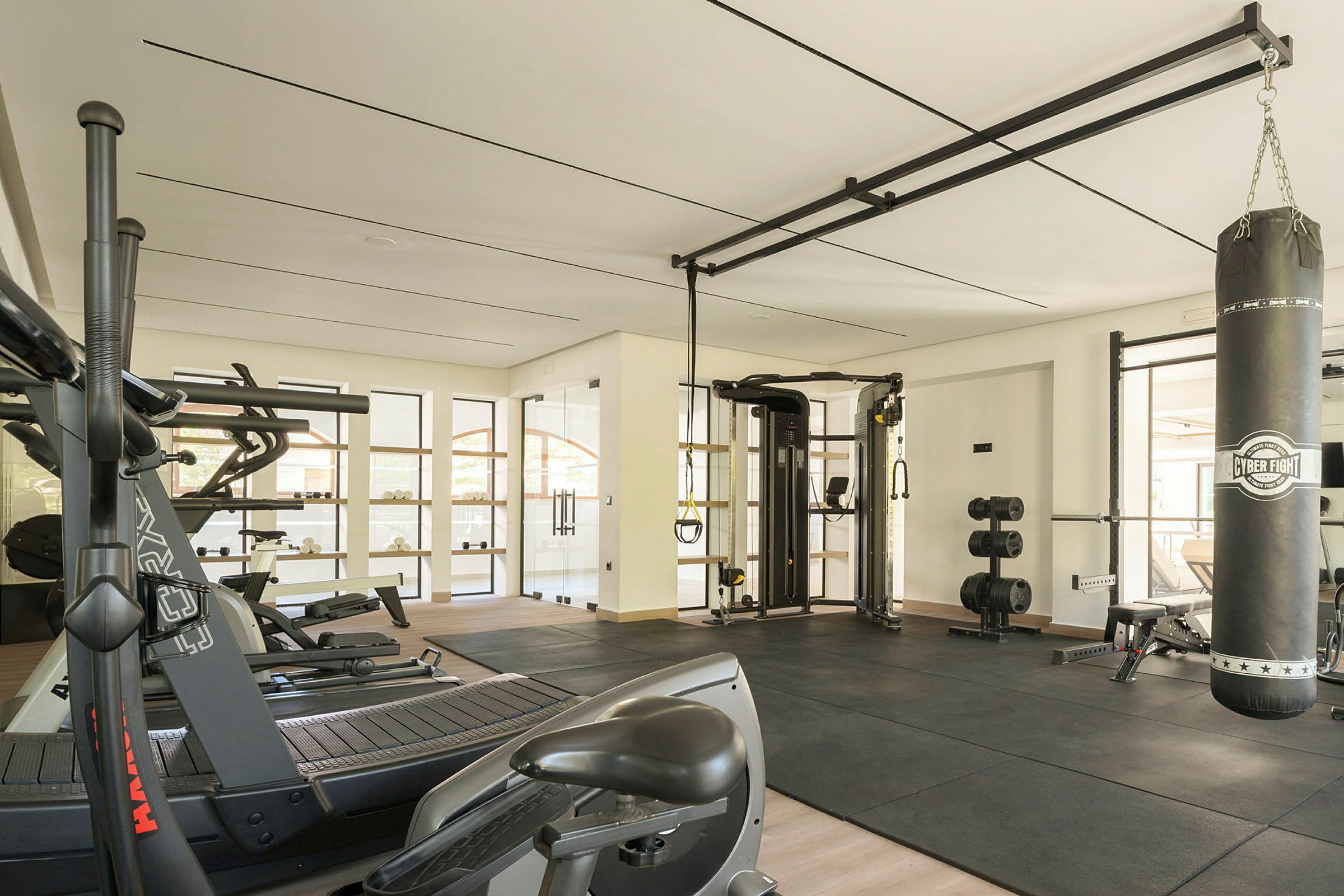 Ett modernt gym med träningsutrustning och en boxningssäck. (AI-genererad text)
