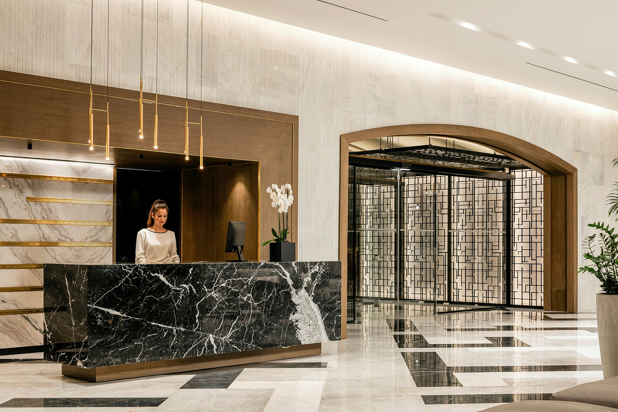Hotellets reception med marmordisk och elegant inredning. (AI-genererad text)