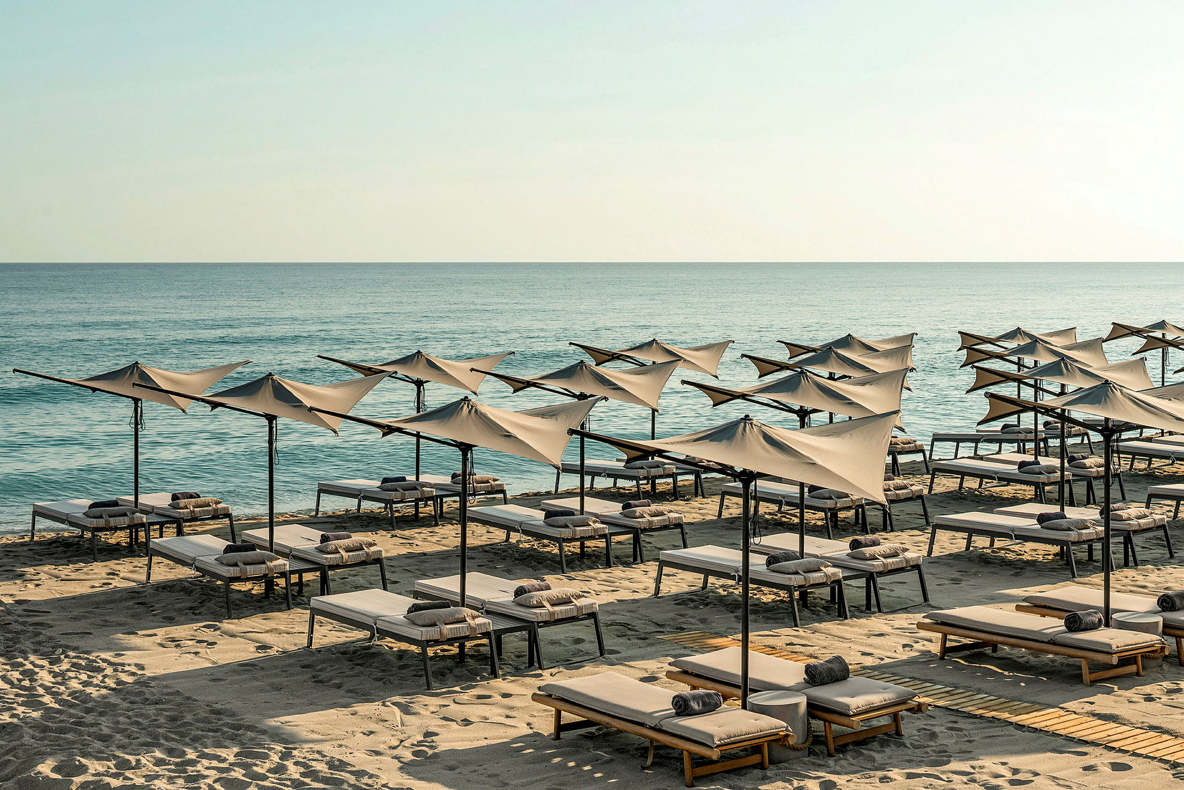 Strand med solstolar och parasoller vid havet. (AI-genererad text)