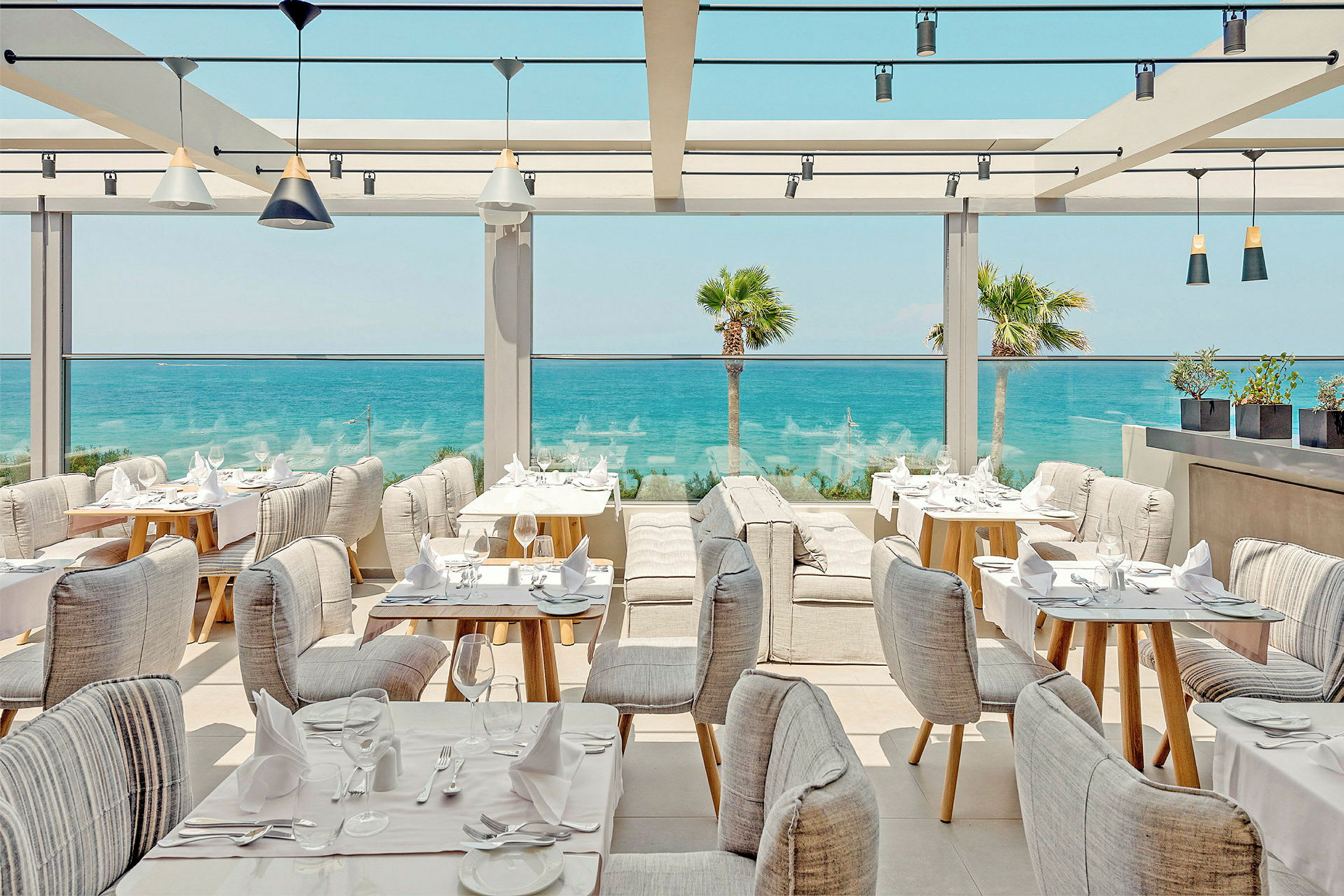 En restaurang med sittplatser vid havet. (AI-genererad text)
