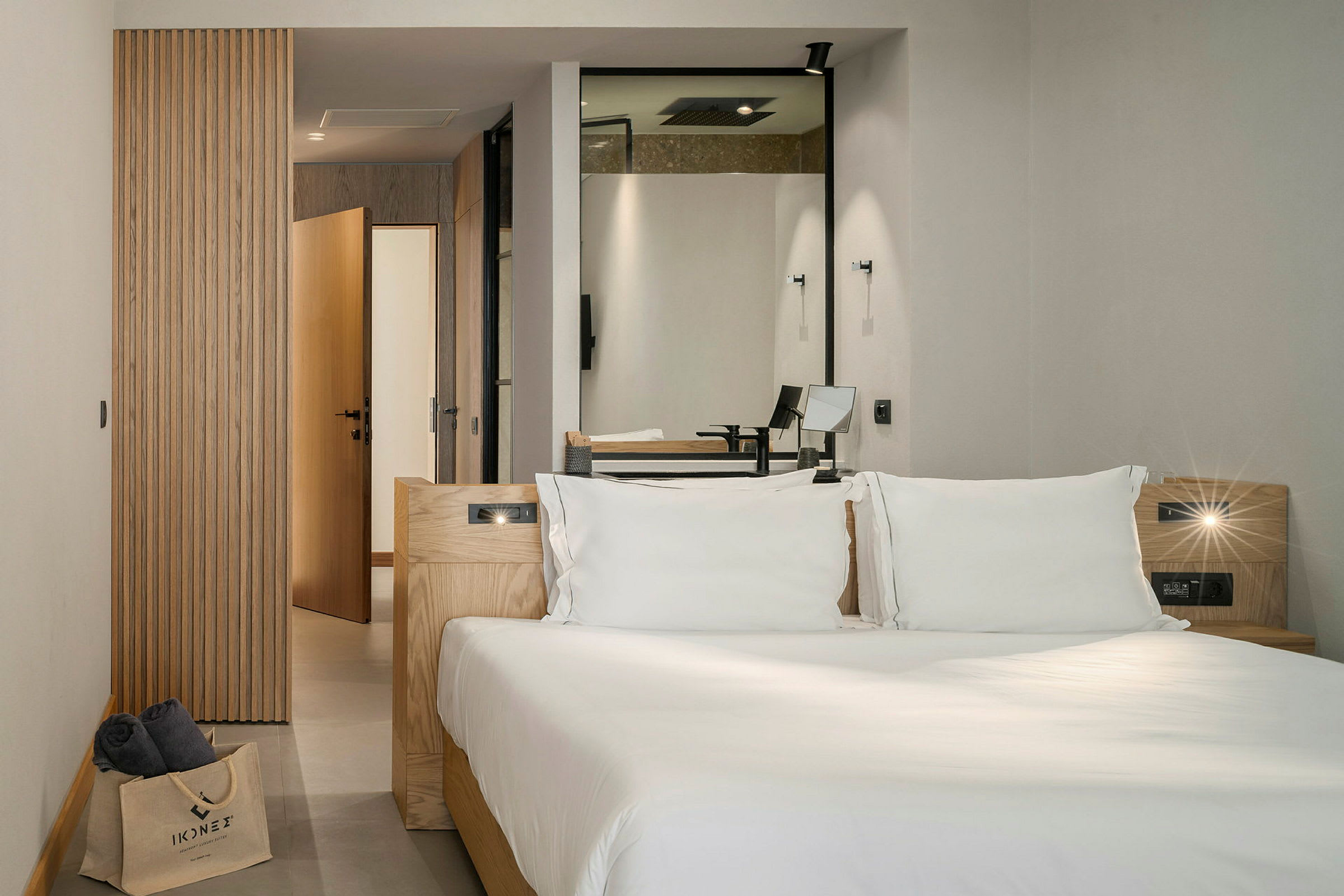Modernt hotellrum med en dubbelsäng, huvudsakligen inrett med trädetaljer och med insyn mot badrum. (AI-genererad text)