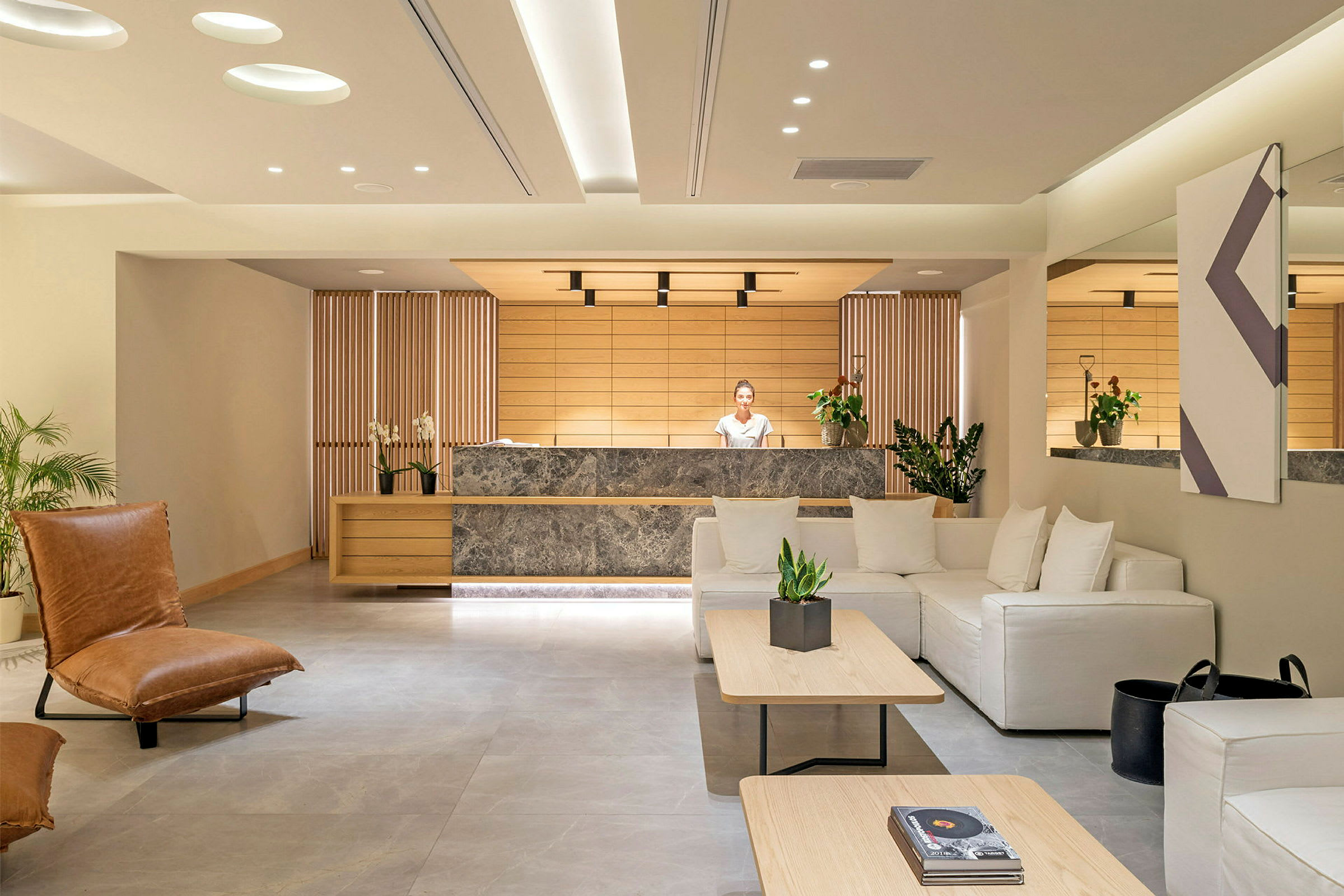 Ett modernt hotellobbyområde med reception och sittgrupp. (AI-genererad text)