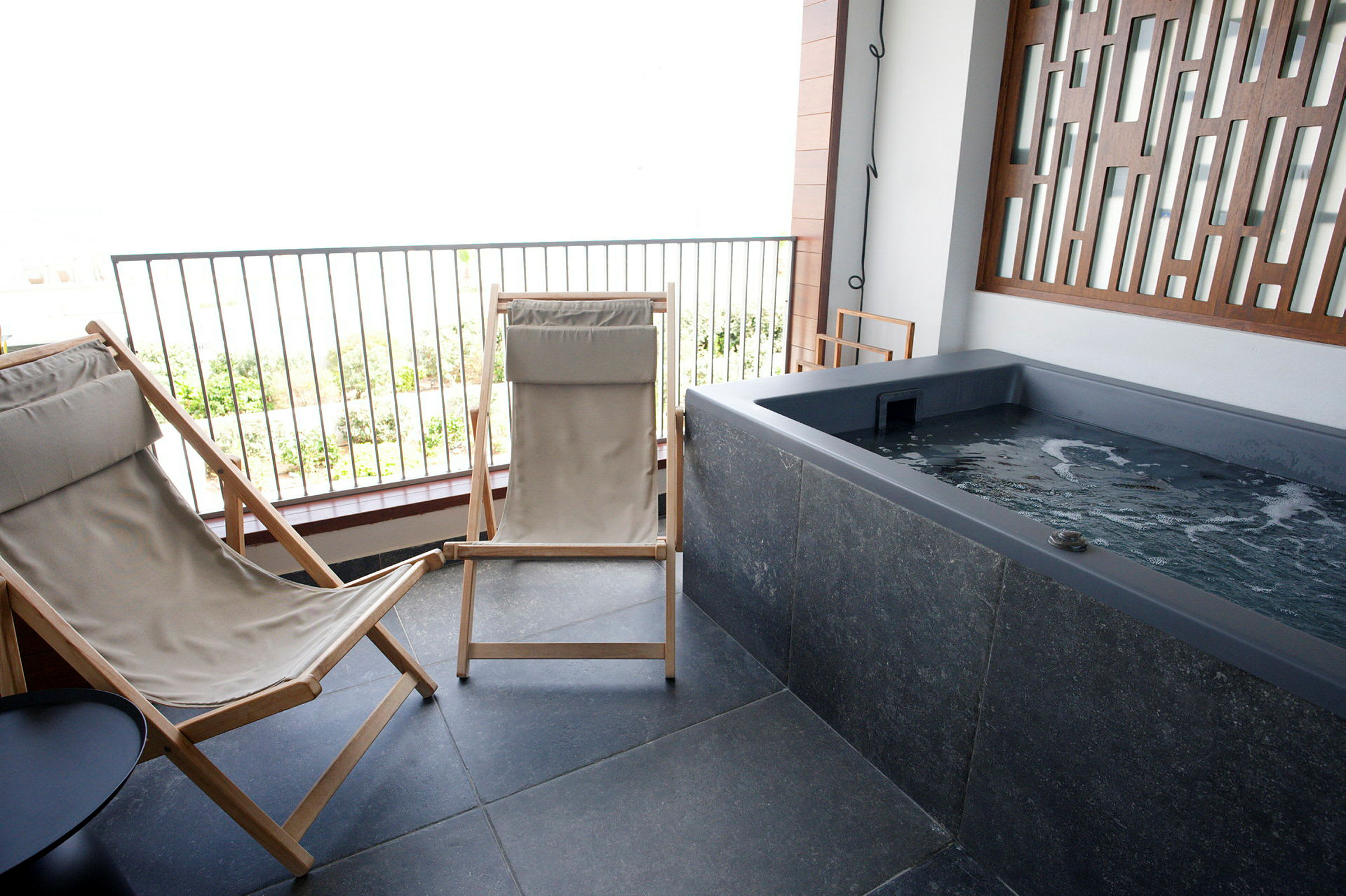 Uteplats med två solstolar och en jacuzzi. (AI-genererad text)