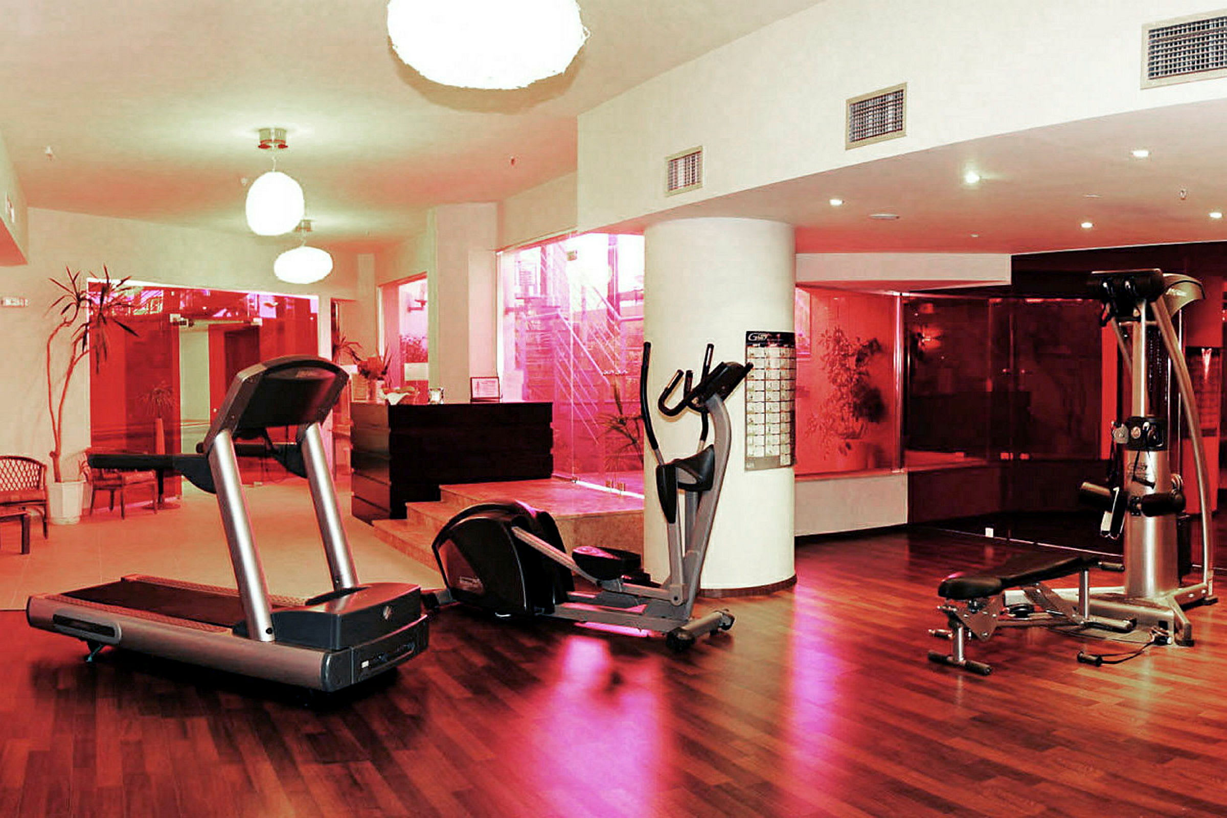 Bild av ett gym med träningsutrustning och trägolv. (AI-genererad text)
