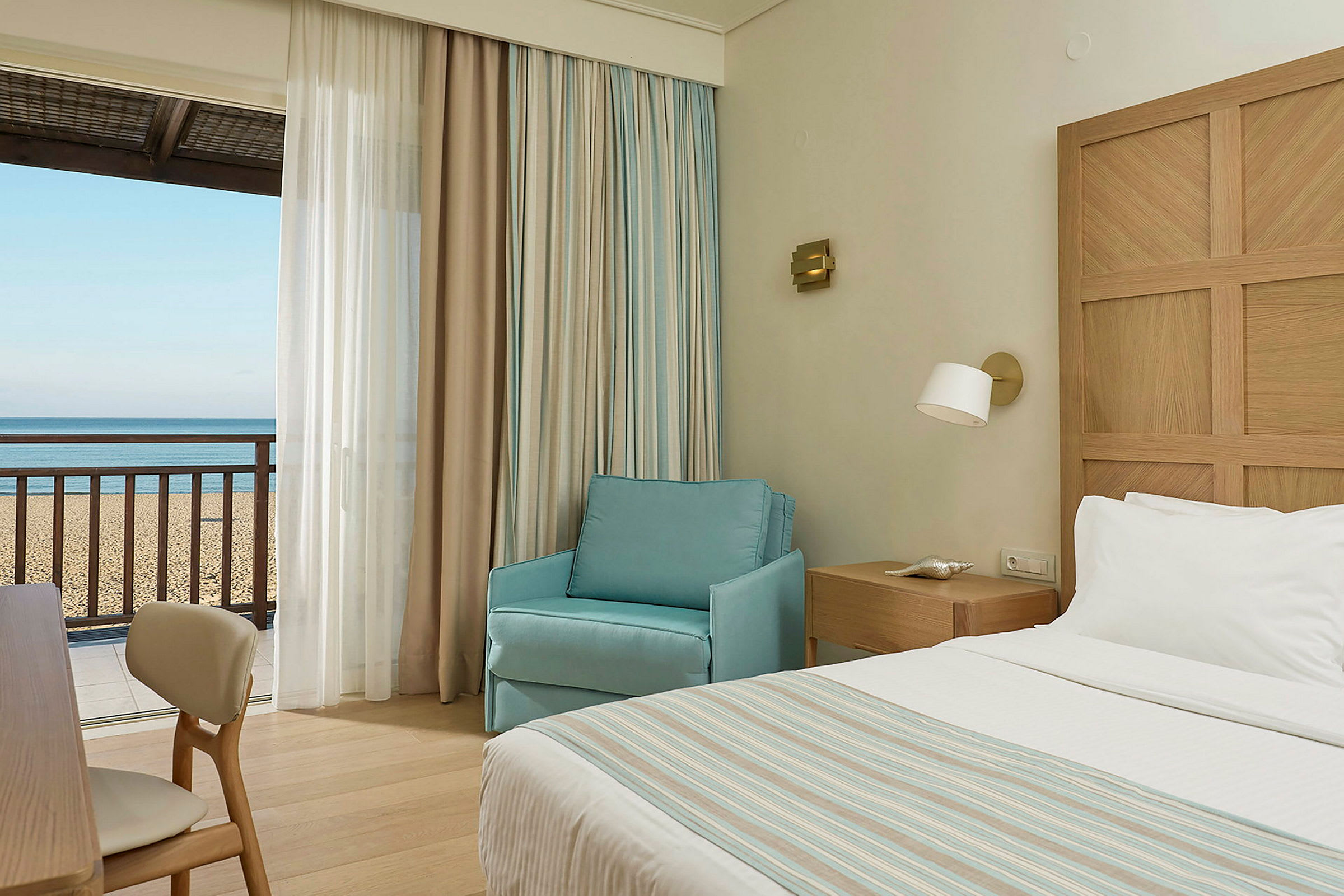 Hotellrum med utsikt mot sandstrand och hav. (AI-genererad text)