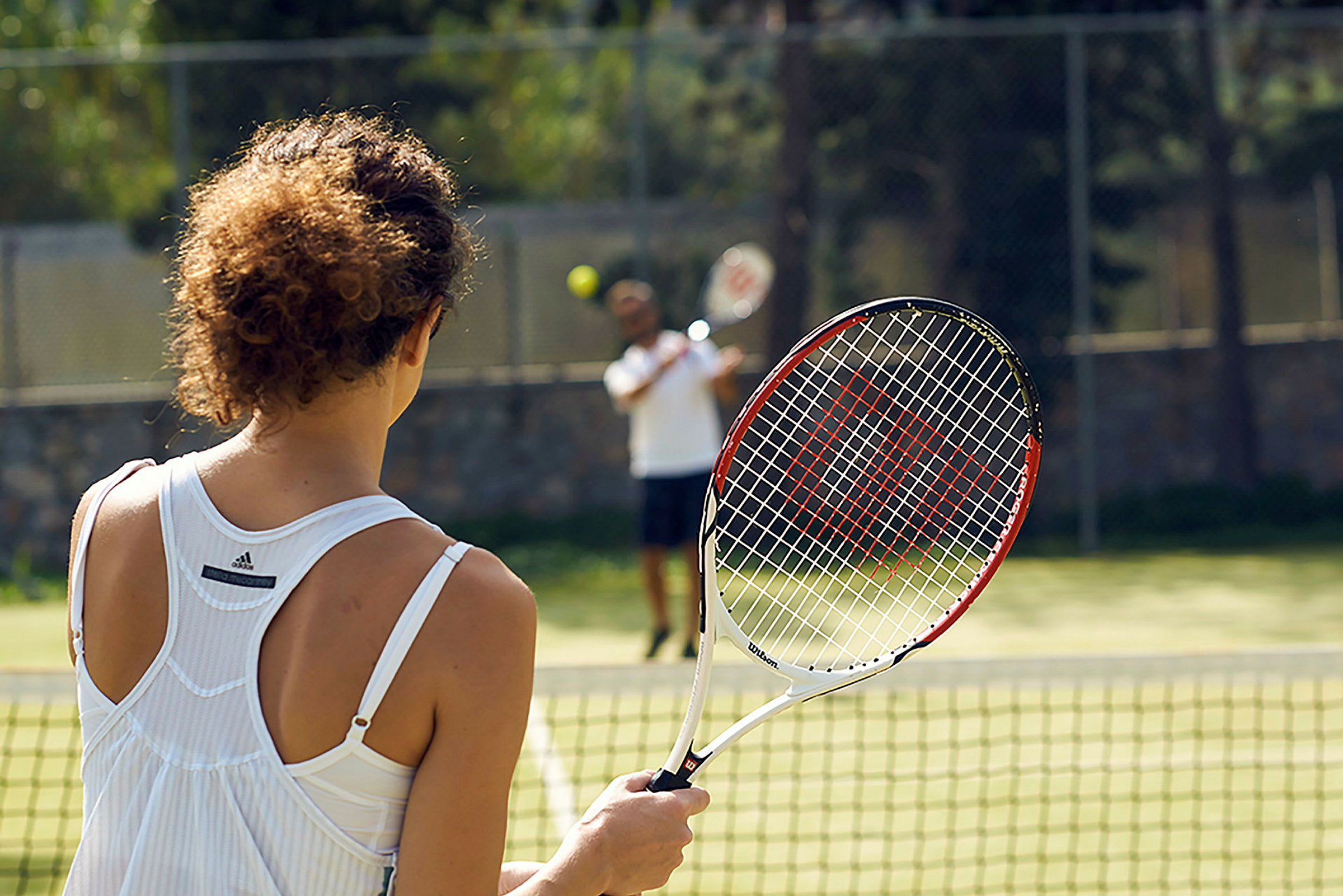 Person håller i en tennisracket på en tennisbana. (AI-genererad text)