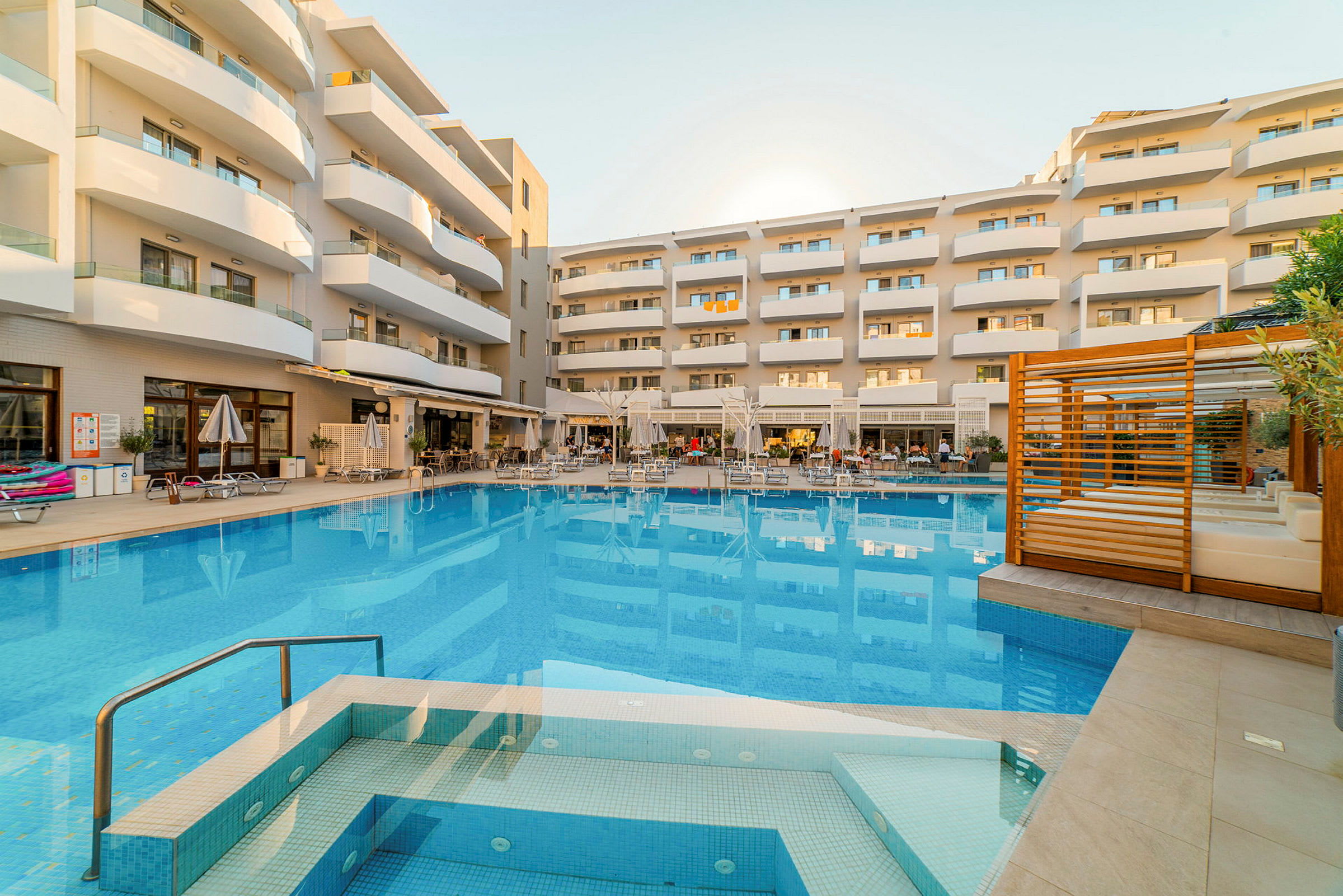 En bild av en semesteranläggning med en pool och omgivande byggnader. (AI-genererad text)