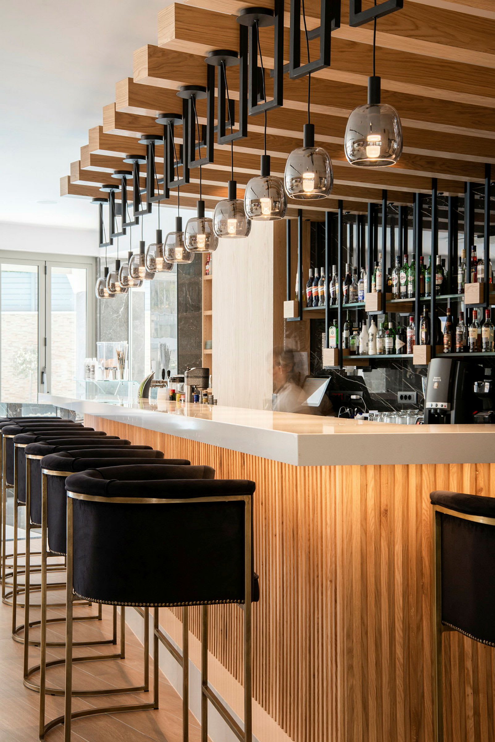 Modernt designad hotellbar med sittplatser och hyllor med flaskor. (AI-genererad text)