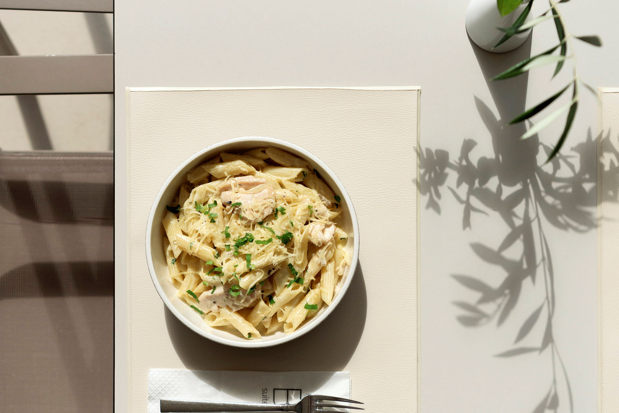 En tallrik med pasta serverad på ett bord. (AI-genererad text)