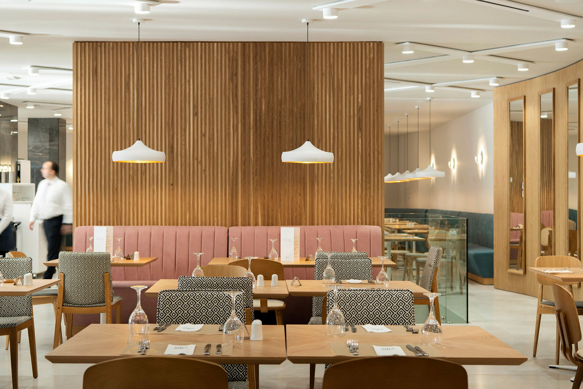 Restaurang med bord och stolar samt dekorativa lampor. (AI-genererad text)