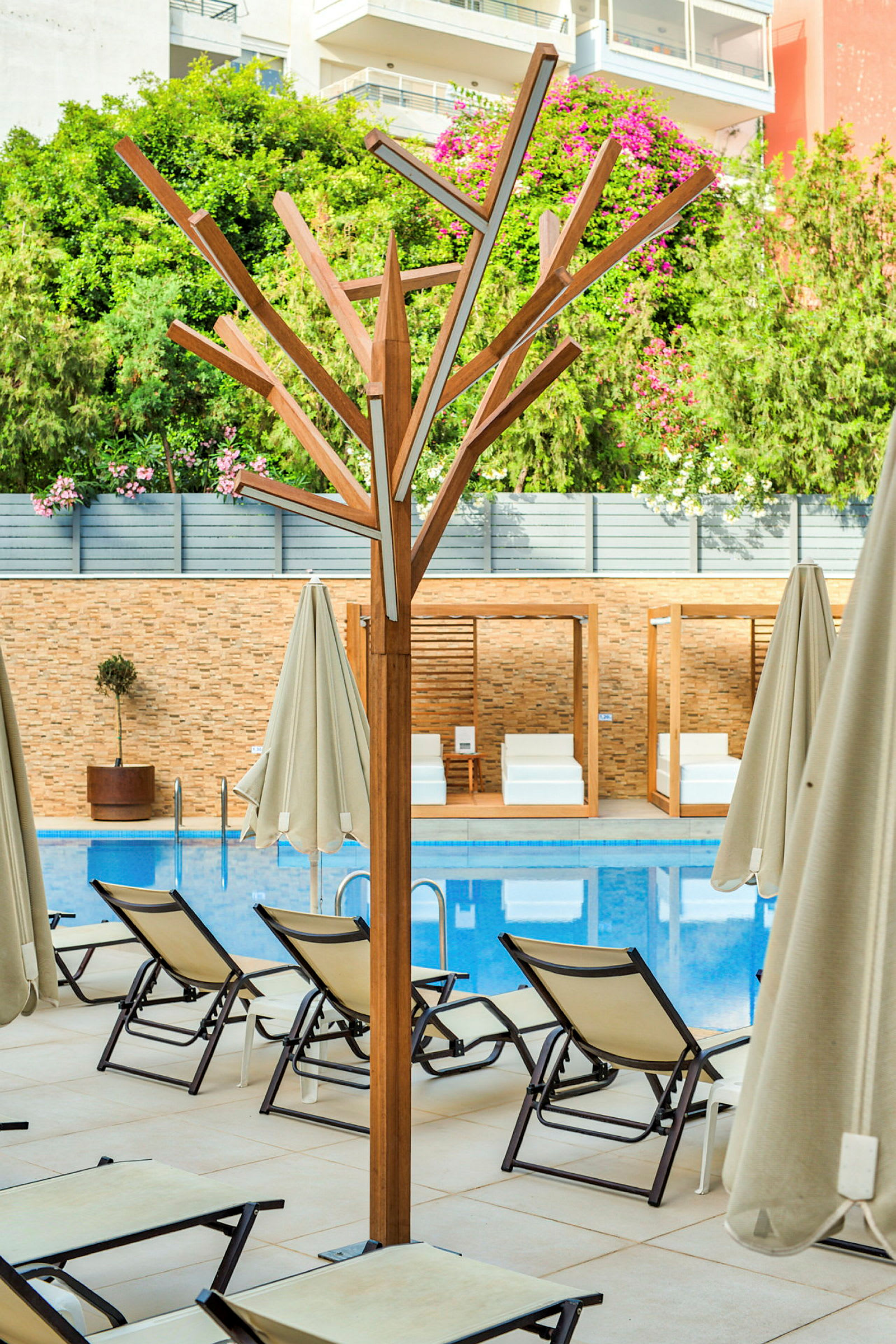 Solstolar vid en pool med parasoller och träkonstruktion. (AI-genererad text)