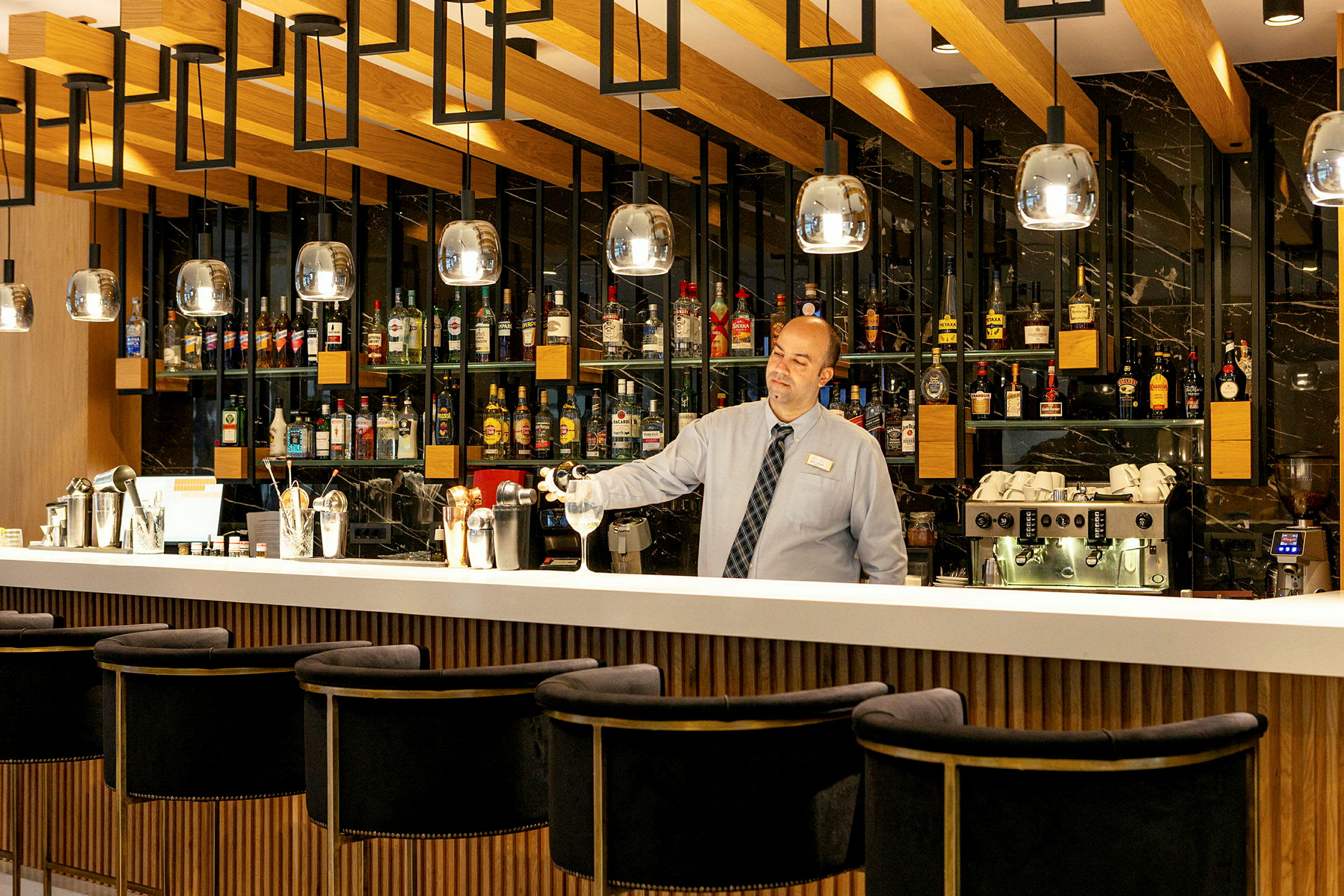 En bartender står bakom en välutrustad bar. (AI-genererad text)
