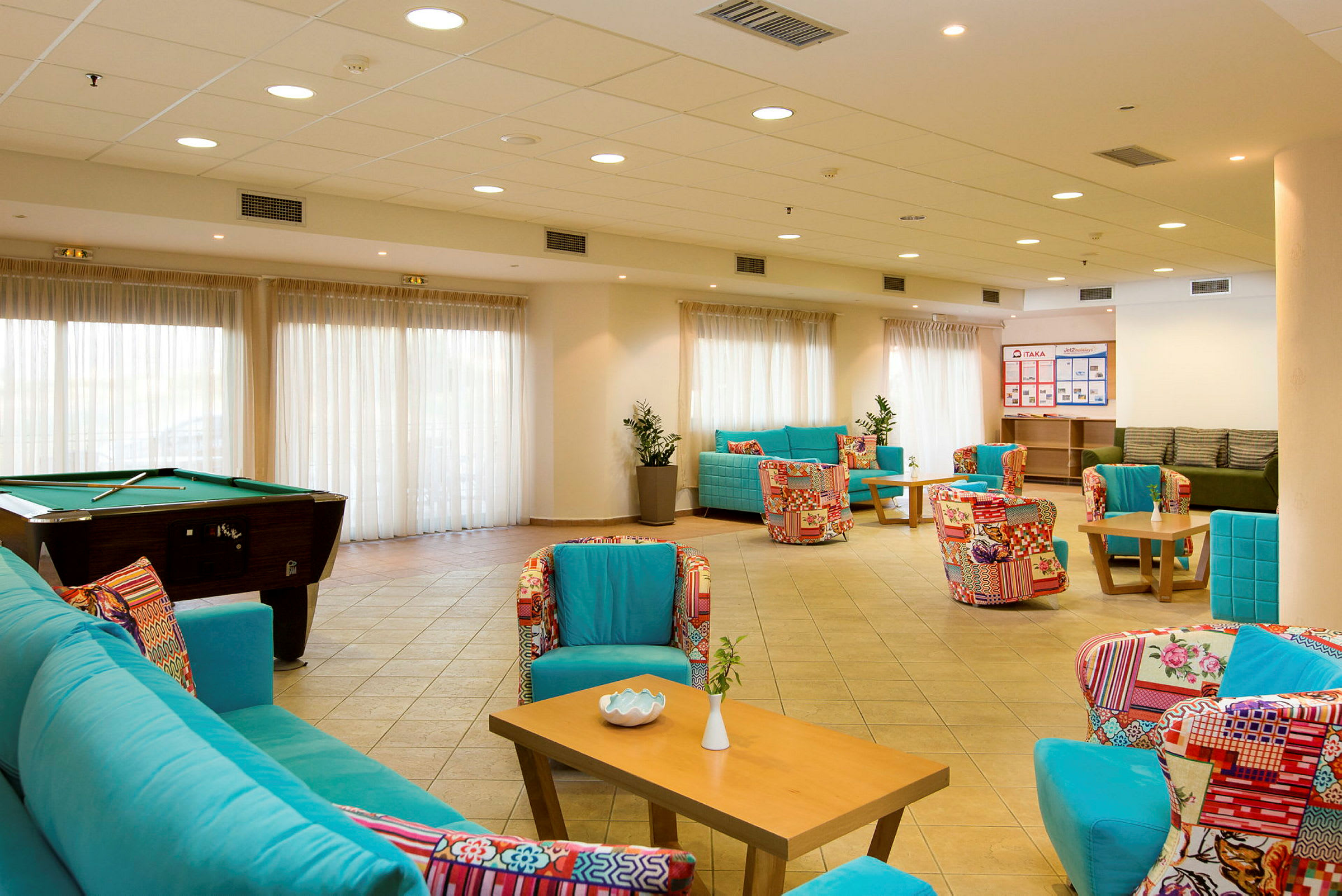 Hotellobby med sittplatser och biljardbord. (AI-genererad text)