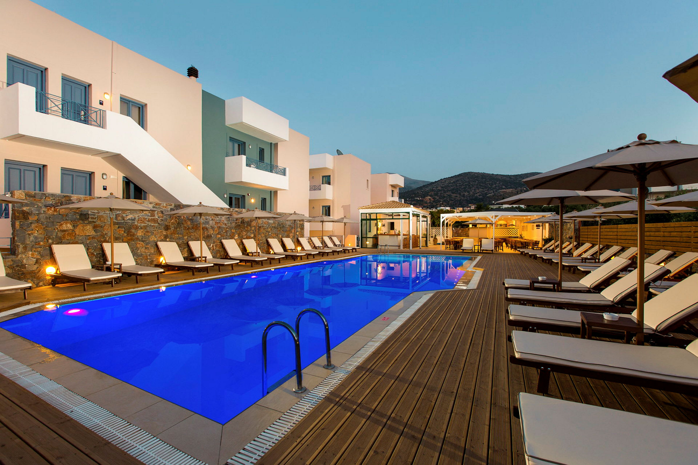 En pool på ett hotell med omgivande solstolar och parasoller. (AI-genererad text)