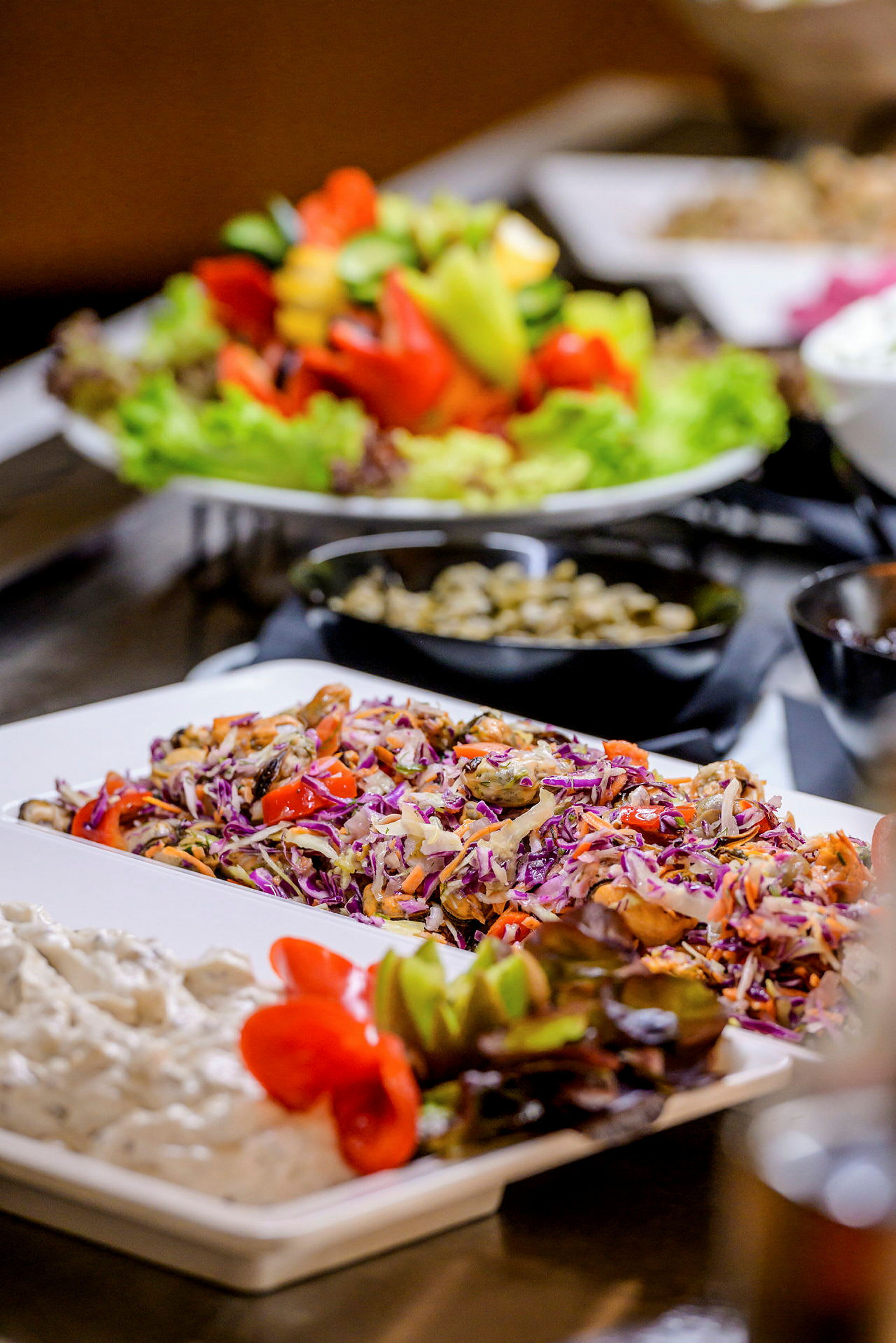 Ett bord med olika maträtter, inklusive sallad, grönsaker och coleslaw. (AI-genererad text)