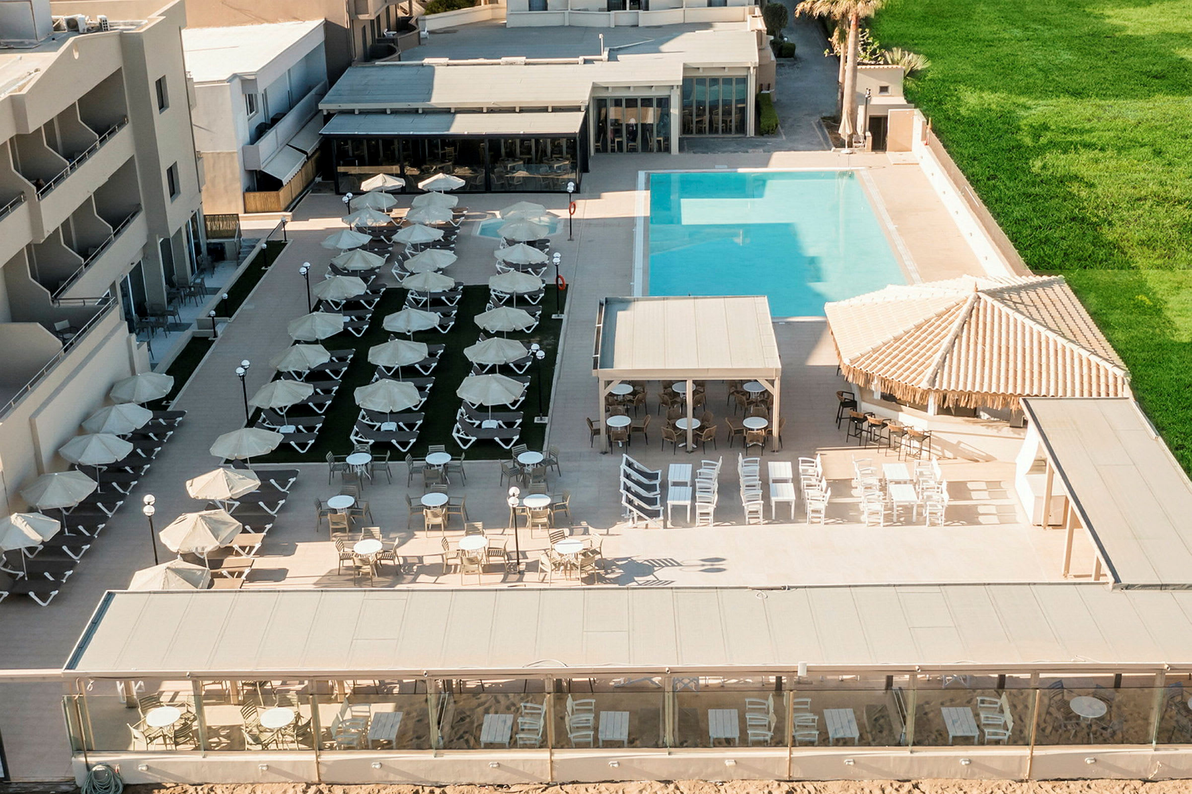 Bild på hotellområde med solstolar, parasoller och swimmingpool. (AI-genererad text)