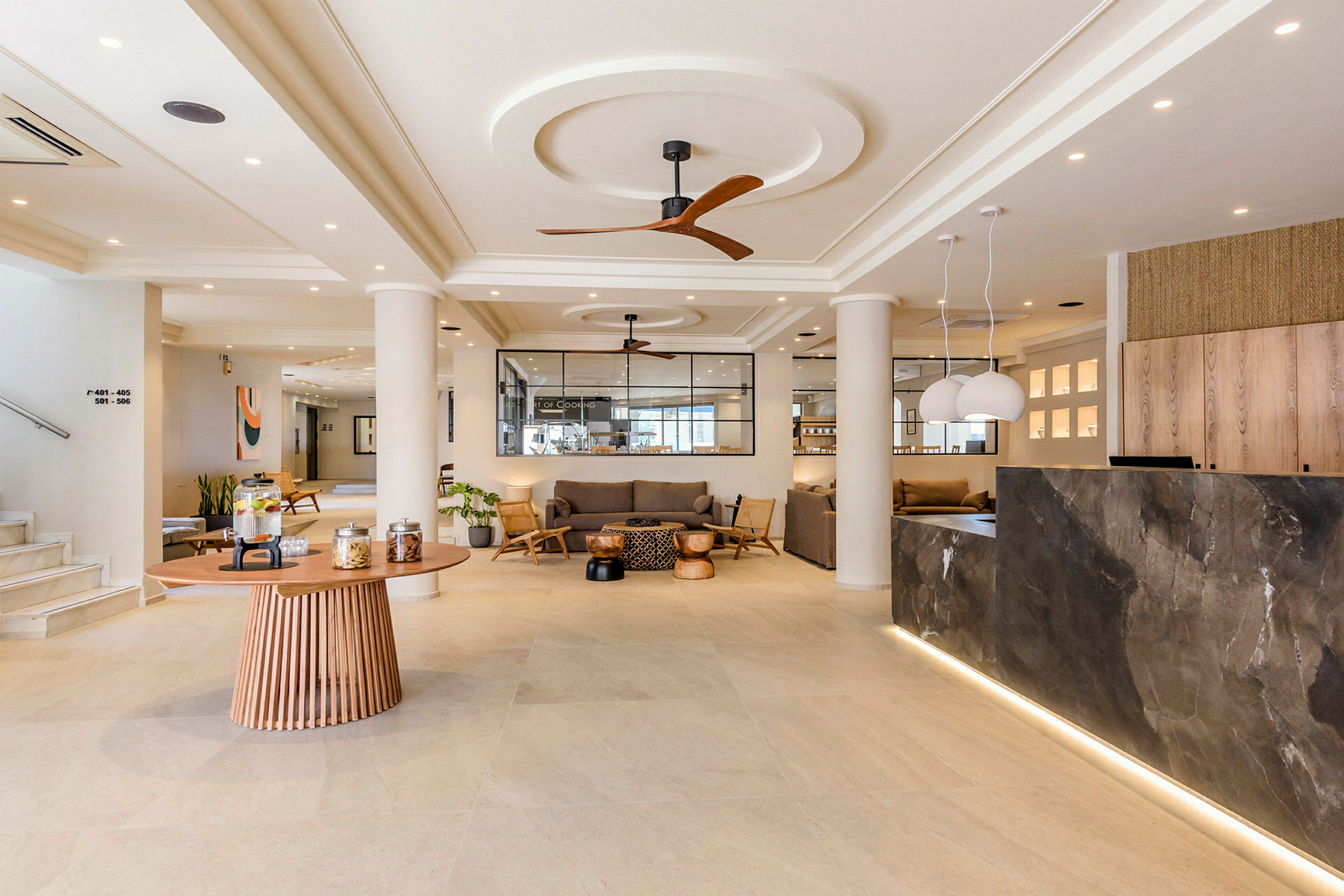 Ett elegant hotellobby med soffgrupper, receptionsdisk och ett runt bord med snacks. (AI-genererad text)