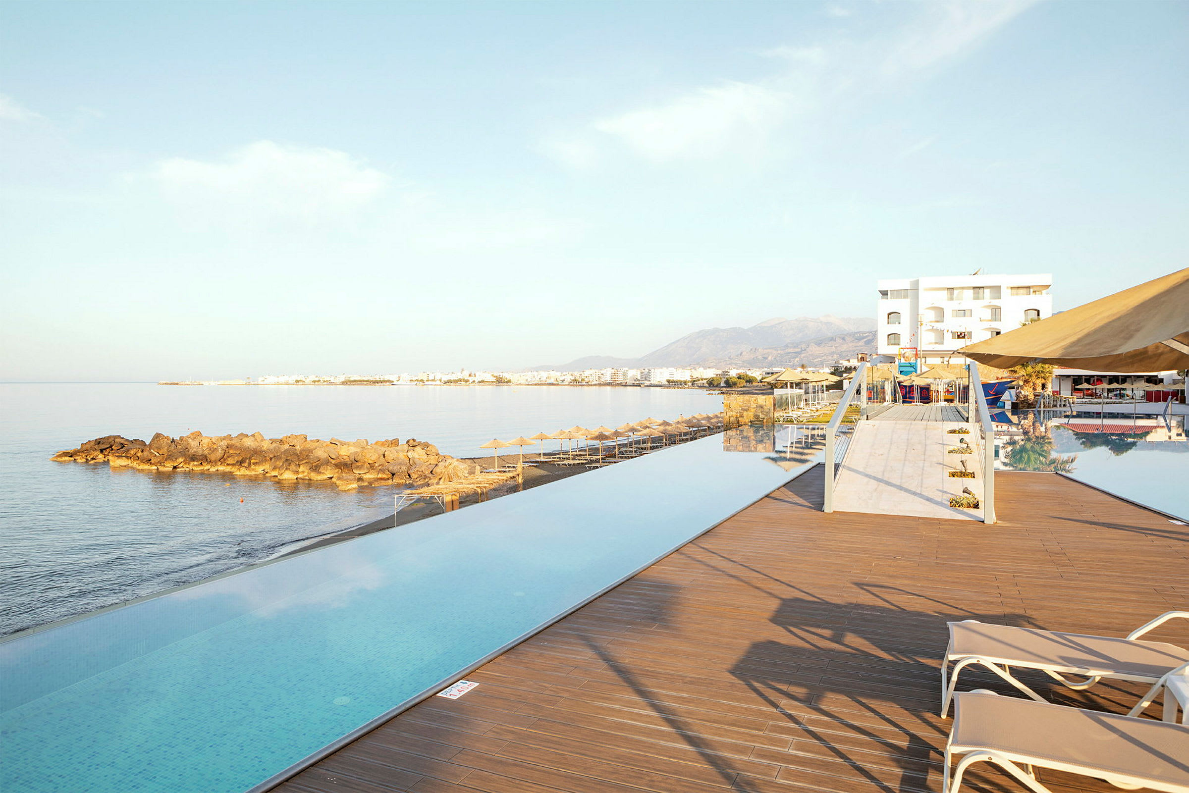 Infinitypool vid havet med utsikt över kust och berg. (AI-genererad text)