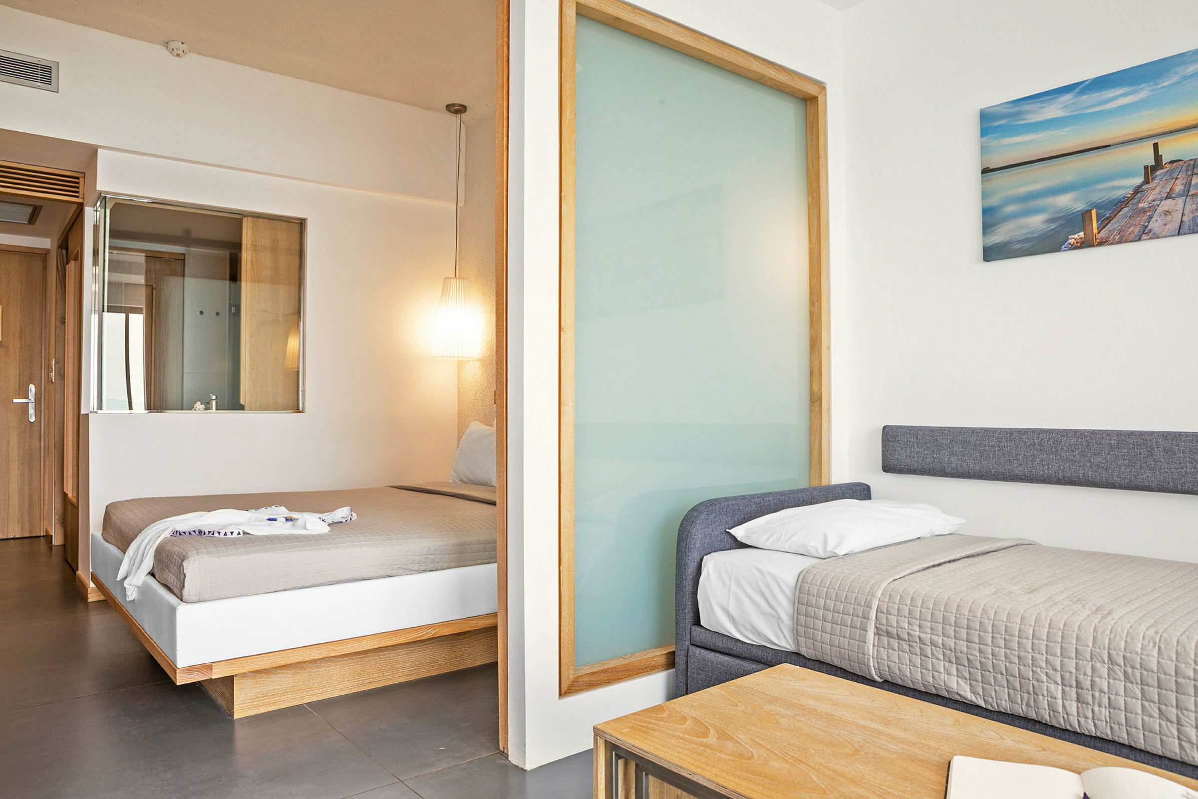 Ett hotellrum med två bäddar, en dubbelsäng och en enkel säng. (AI-genererad text)