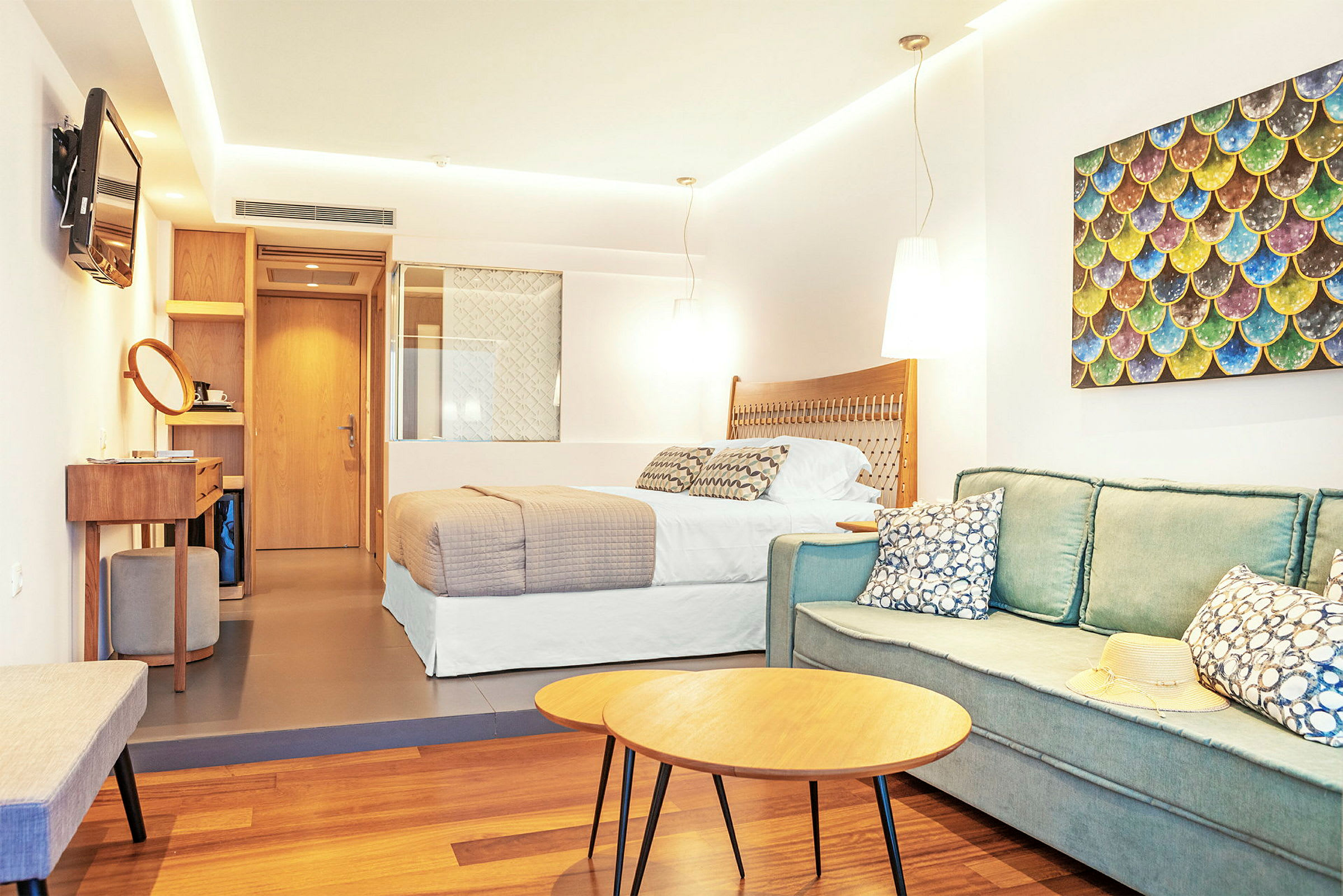 Ett hotellrum med en säng, sittgrupp och dekoration. (AI-genererad text)