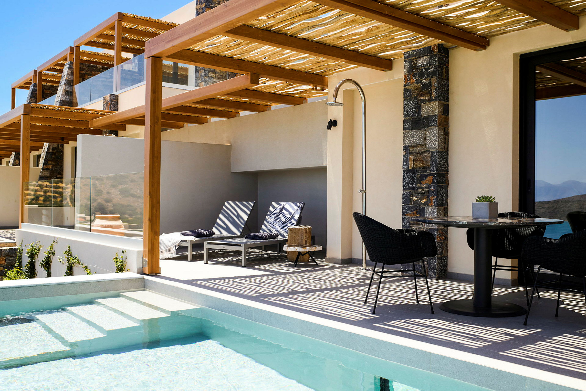 Utomhusområde med pool, solstolar och matbord under en pergola. (AI-genererad text)