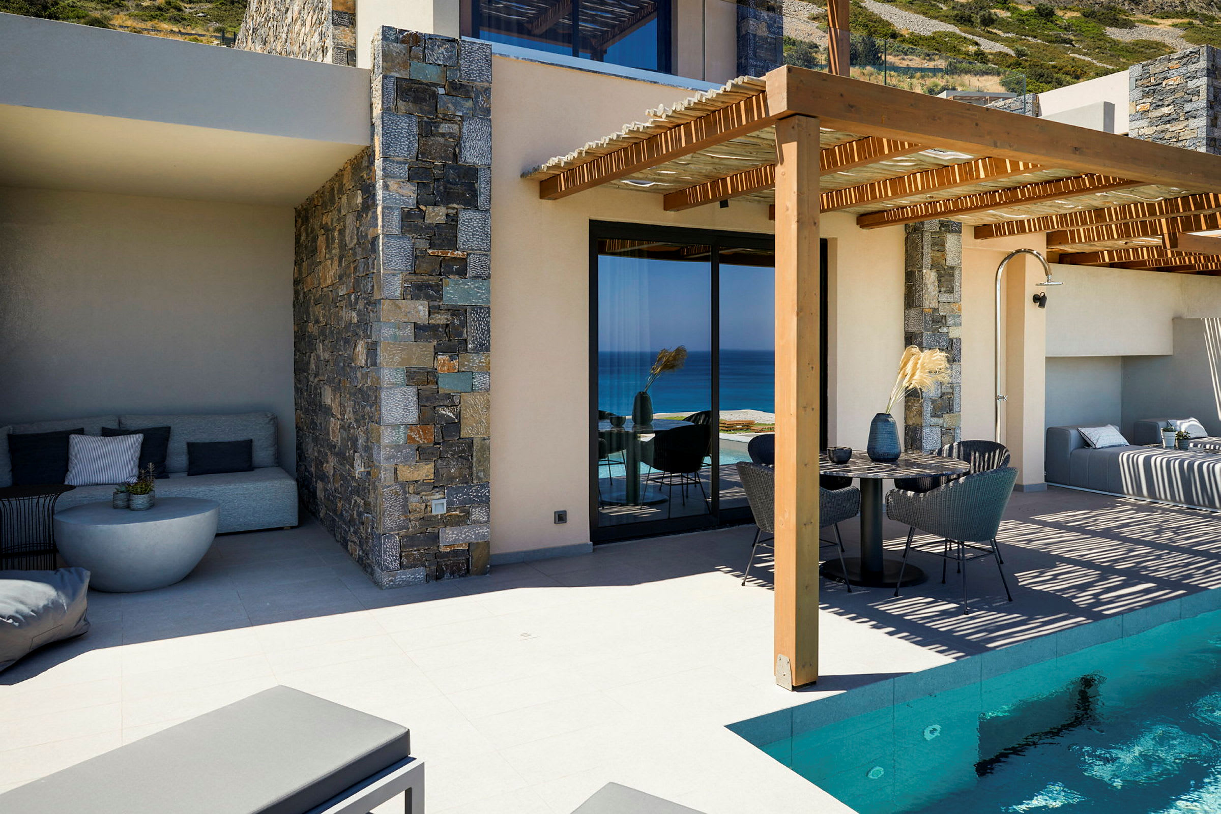 Modernt hus med pool, uteplats och utsikt över havet. (AI-genererad text)