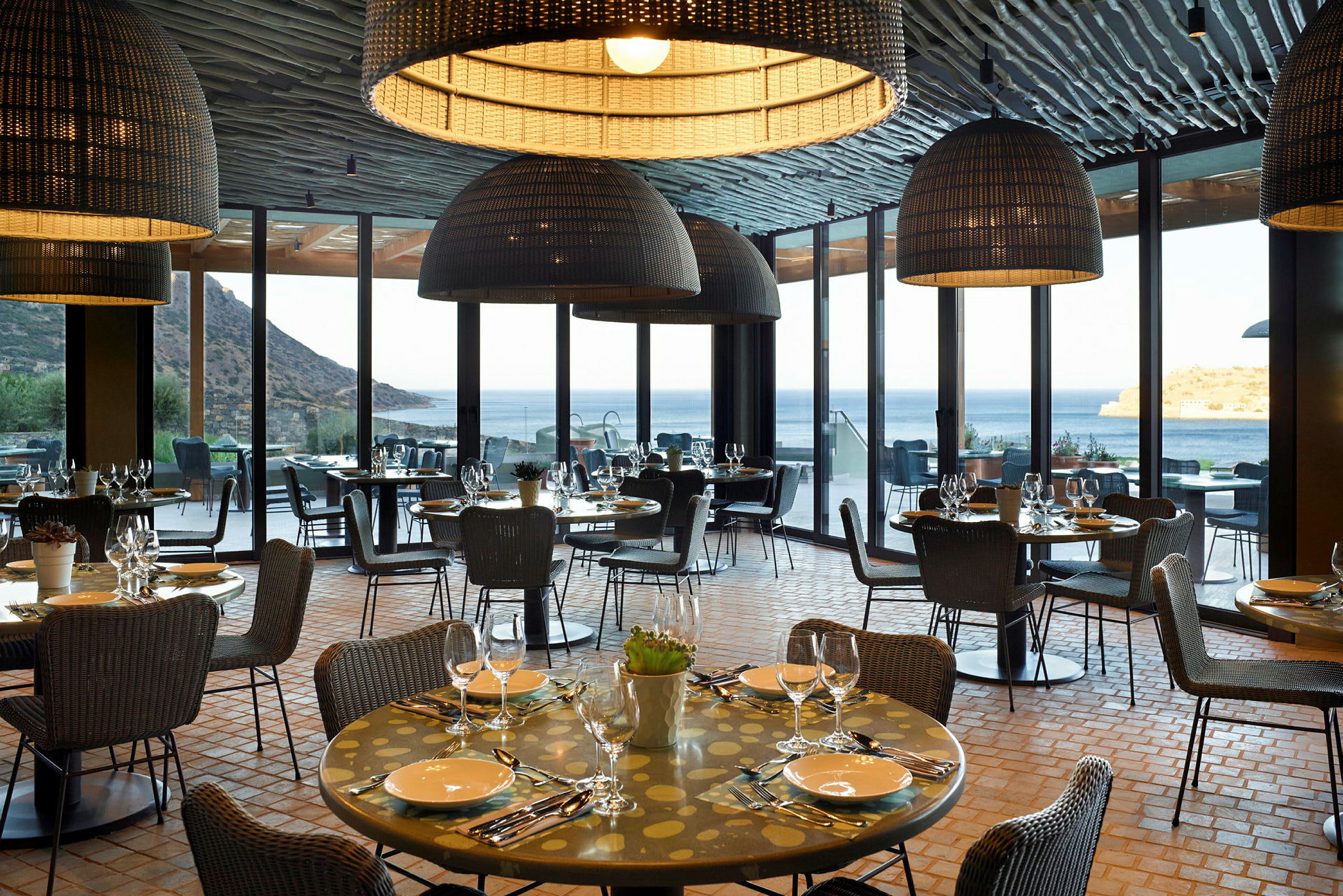 En restaurang med dukade bord belägen med utsikt över havet. (AI-genererad text)