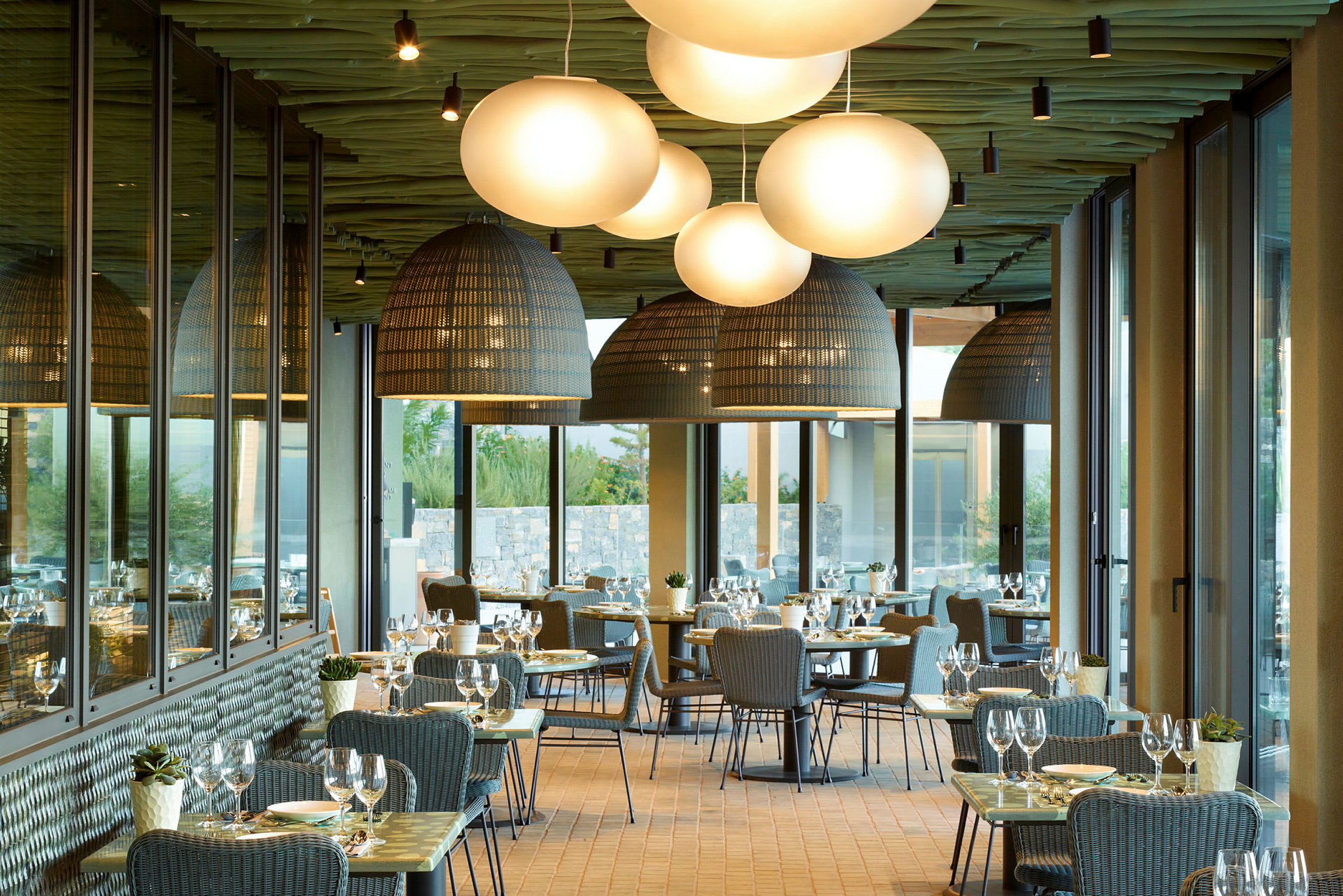 Restaurang med dukade bord och stora lampor. (AI-genererad text)
